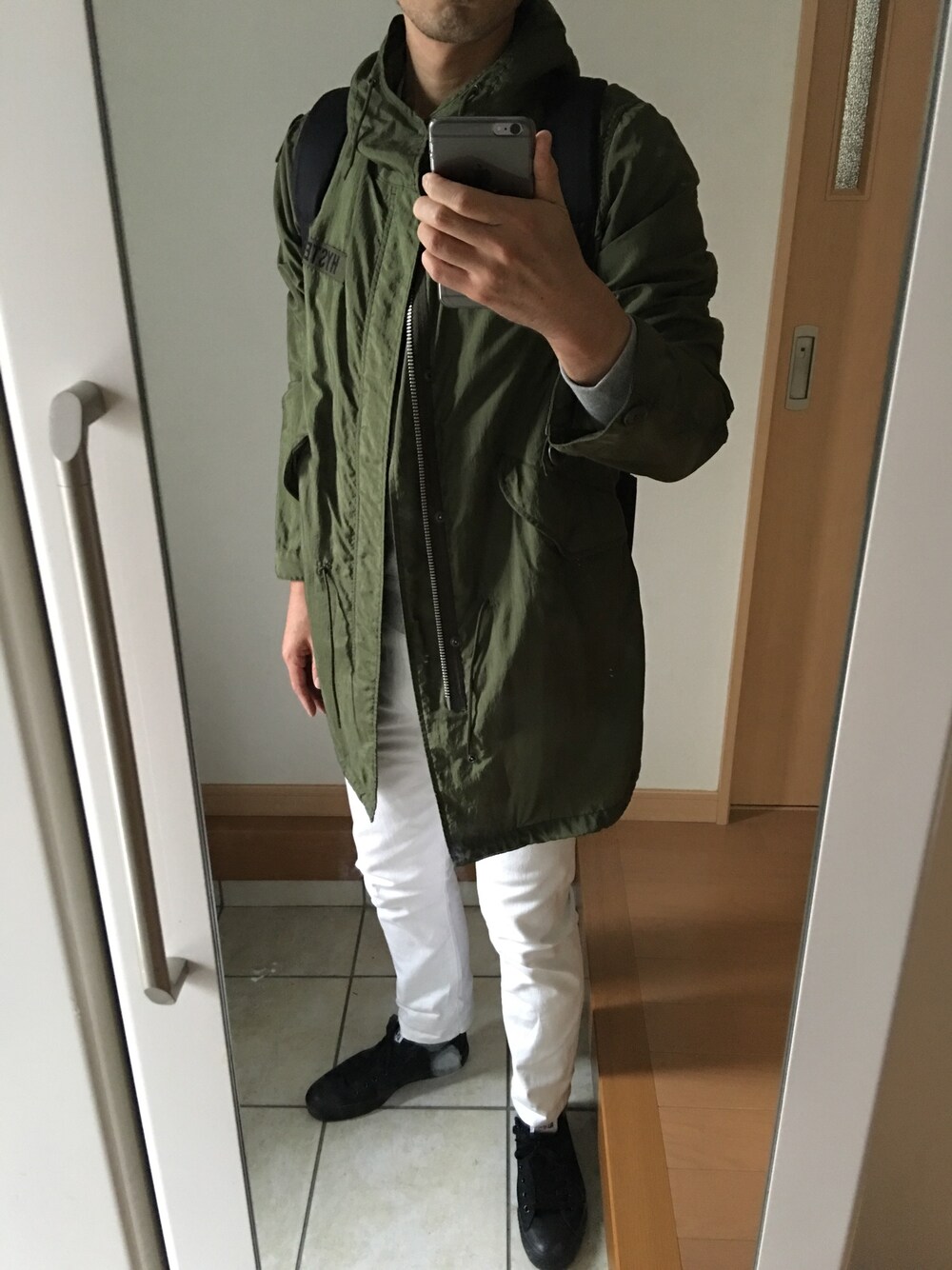 グリーン系のその他アウター、ブラック系のスニーカー、ブラック系のバックパック/リュックを着用したメンズの秋コーディネートの1枚目の写真