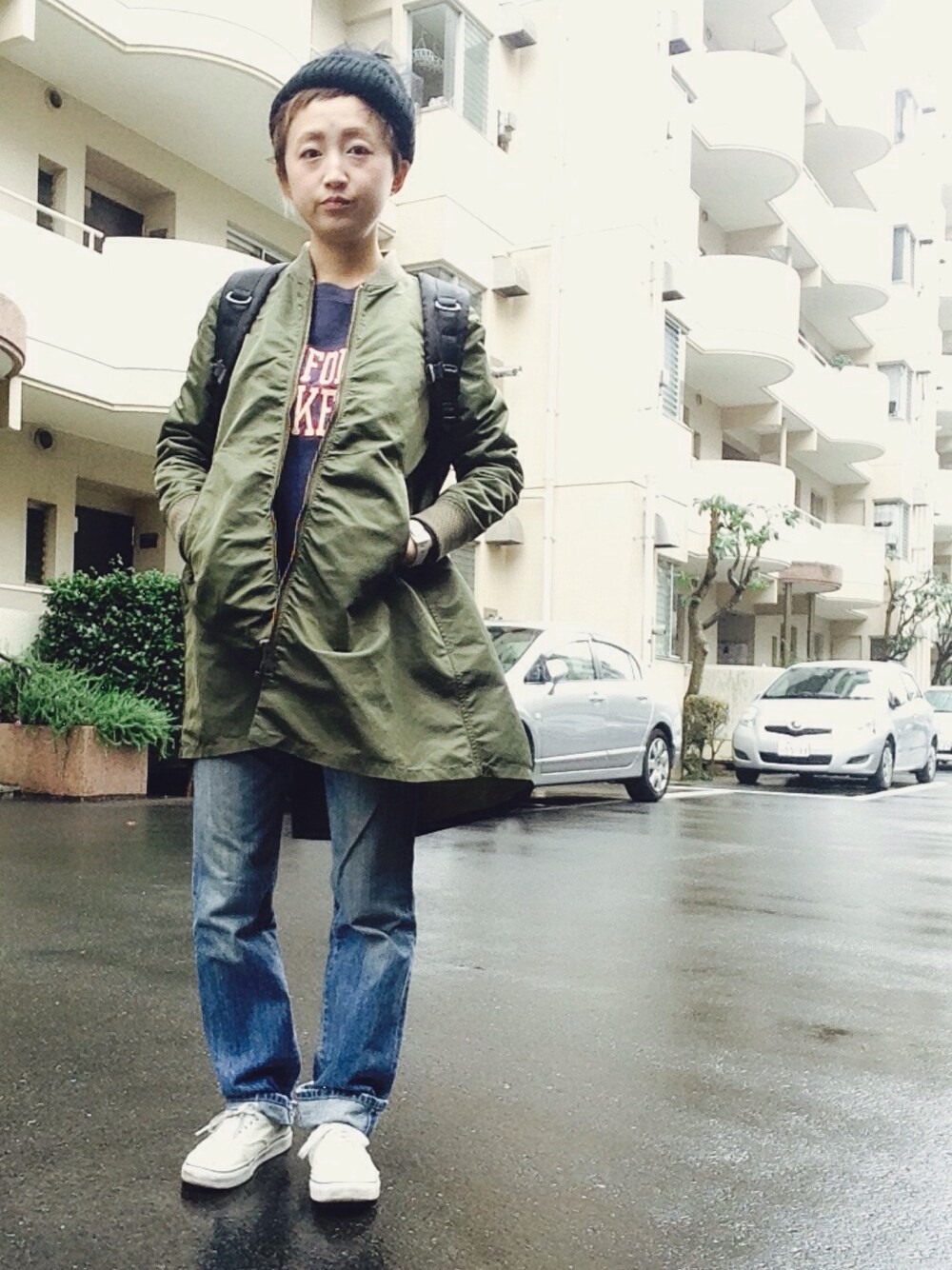 ブラック系のバックパック/リュック、ブルー系のスウェット、グリーン系のミリタリージャケットを着用したレディースの秋コーディネートの1枚目の写真