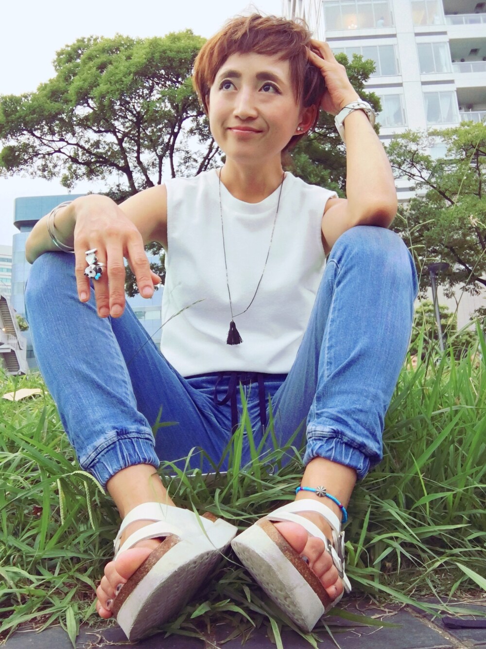 ホワイト系のTシャツ/カットソー、ブルー系のパンツ、ホワイト系のサンダルを着用したレディースの夏コーディネートの1枚目の写真