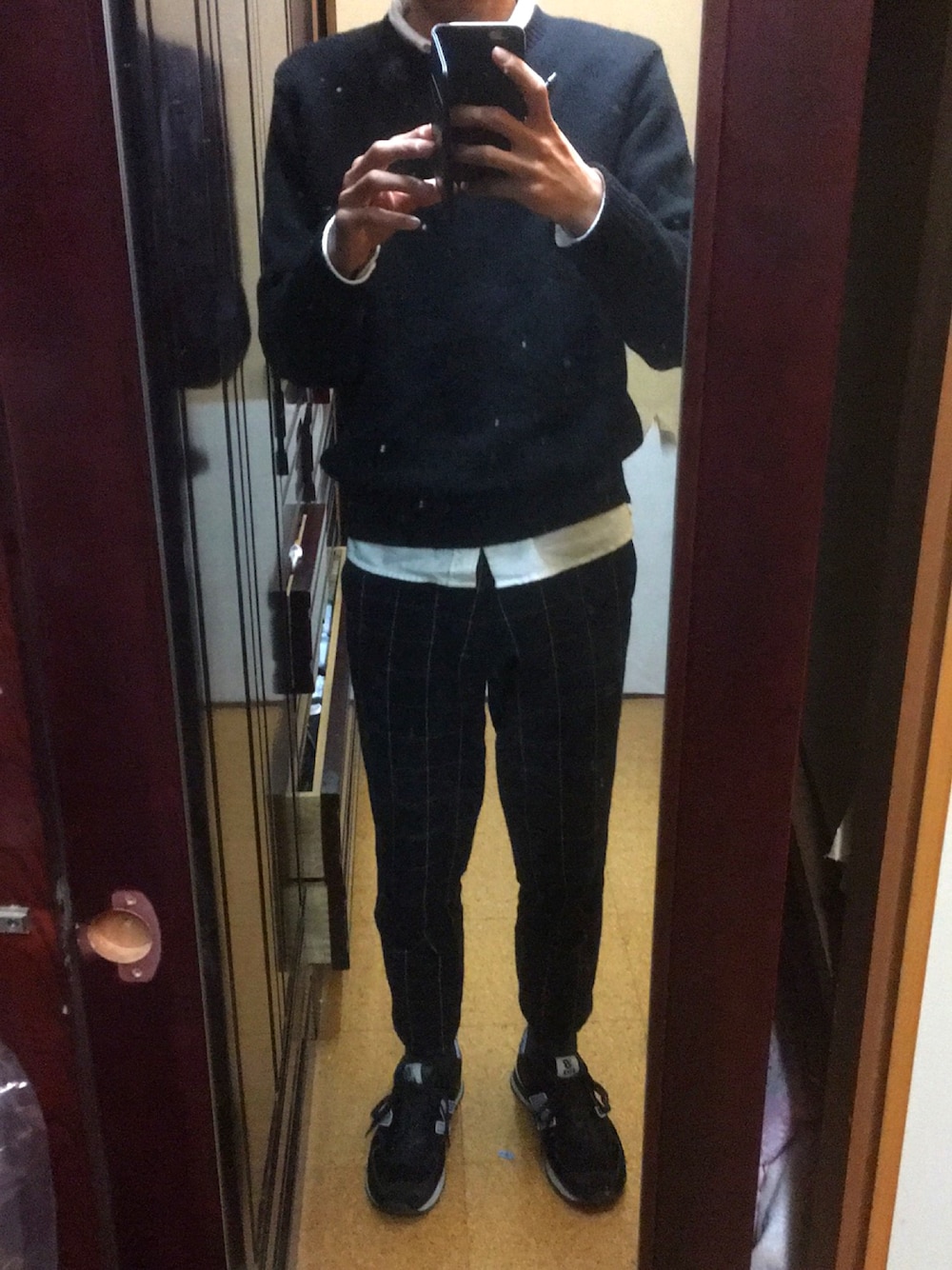 ブラック系のニット/セーター、ブルー系のスラックス、ホワイト系のシャツ/ブラウスを着用したメンズの冬コーディネートの1枚目の写真