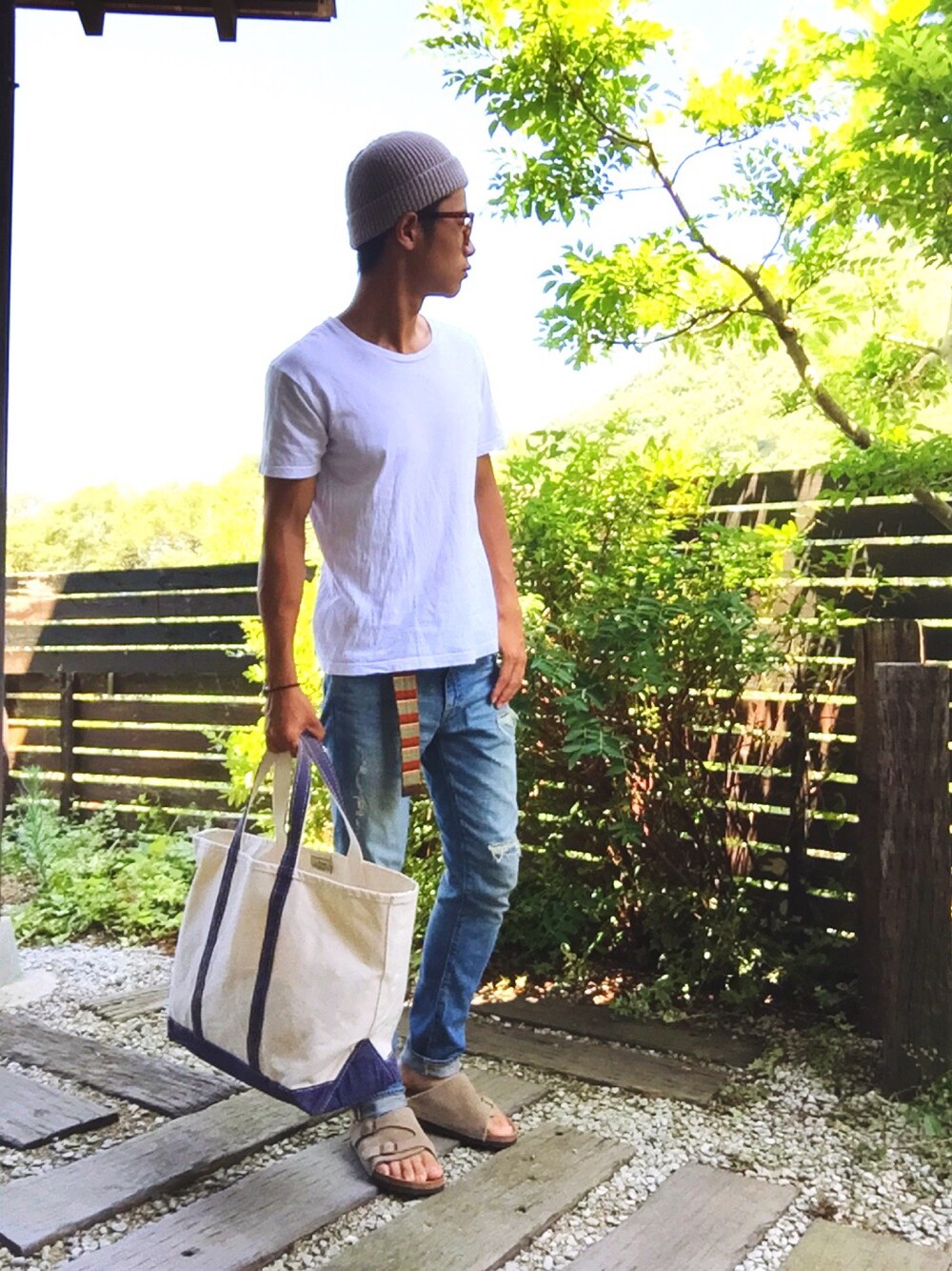 ホワイト系のTシャツ/カットソー、ブルー系のデニムパンツ、ベージュ系のサンダルを着用したメンズの夏コーディネートの1枚目の写真