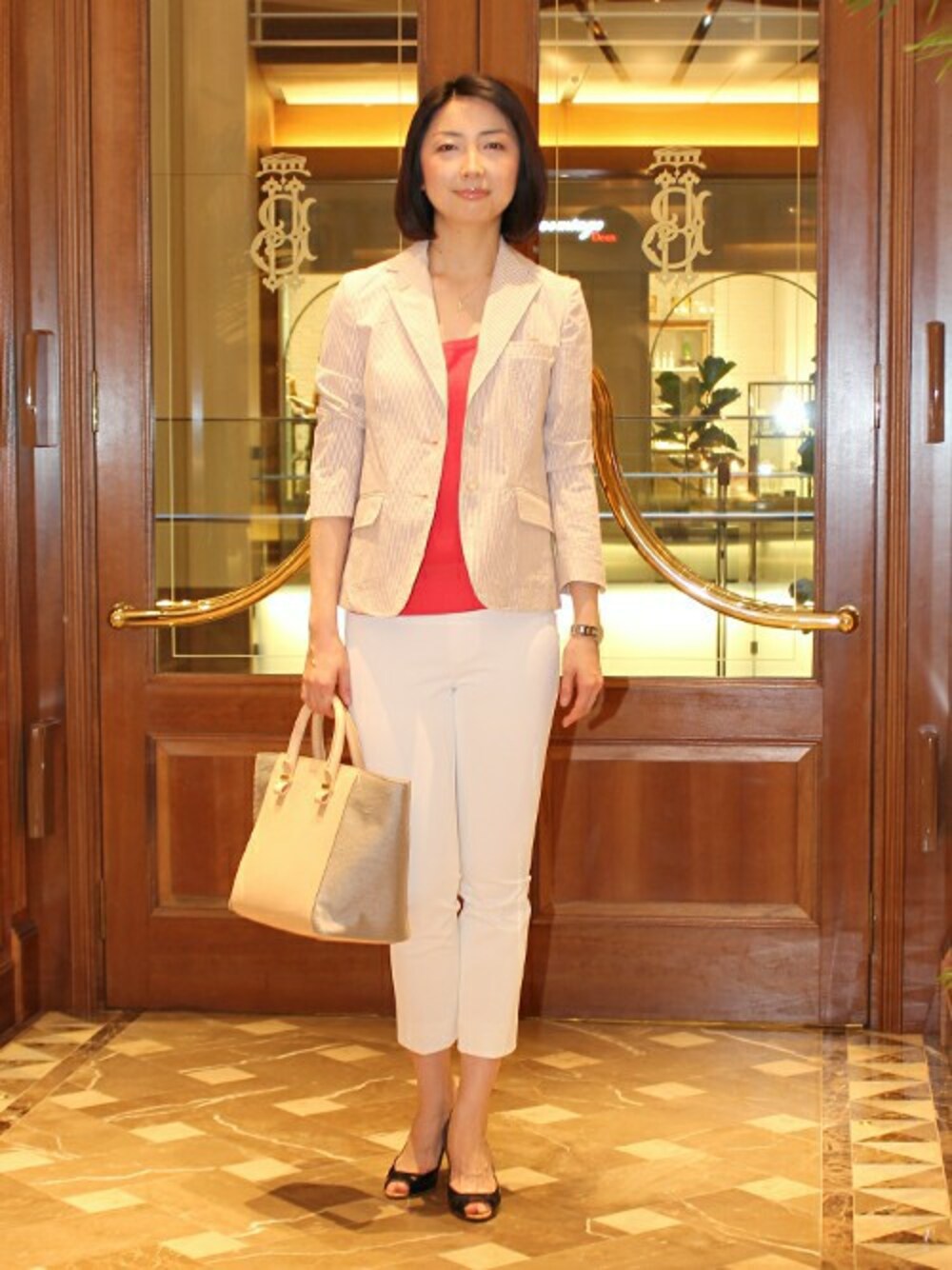 レッド系のニット/セーター、オレンジ系のテーラードジャケット、ホワイト系のその他パンツを着用したレディースの春コーディネートの1枚目の写真