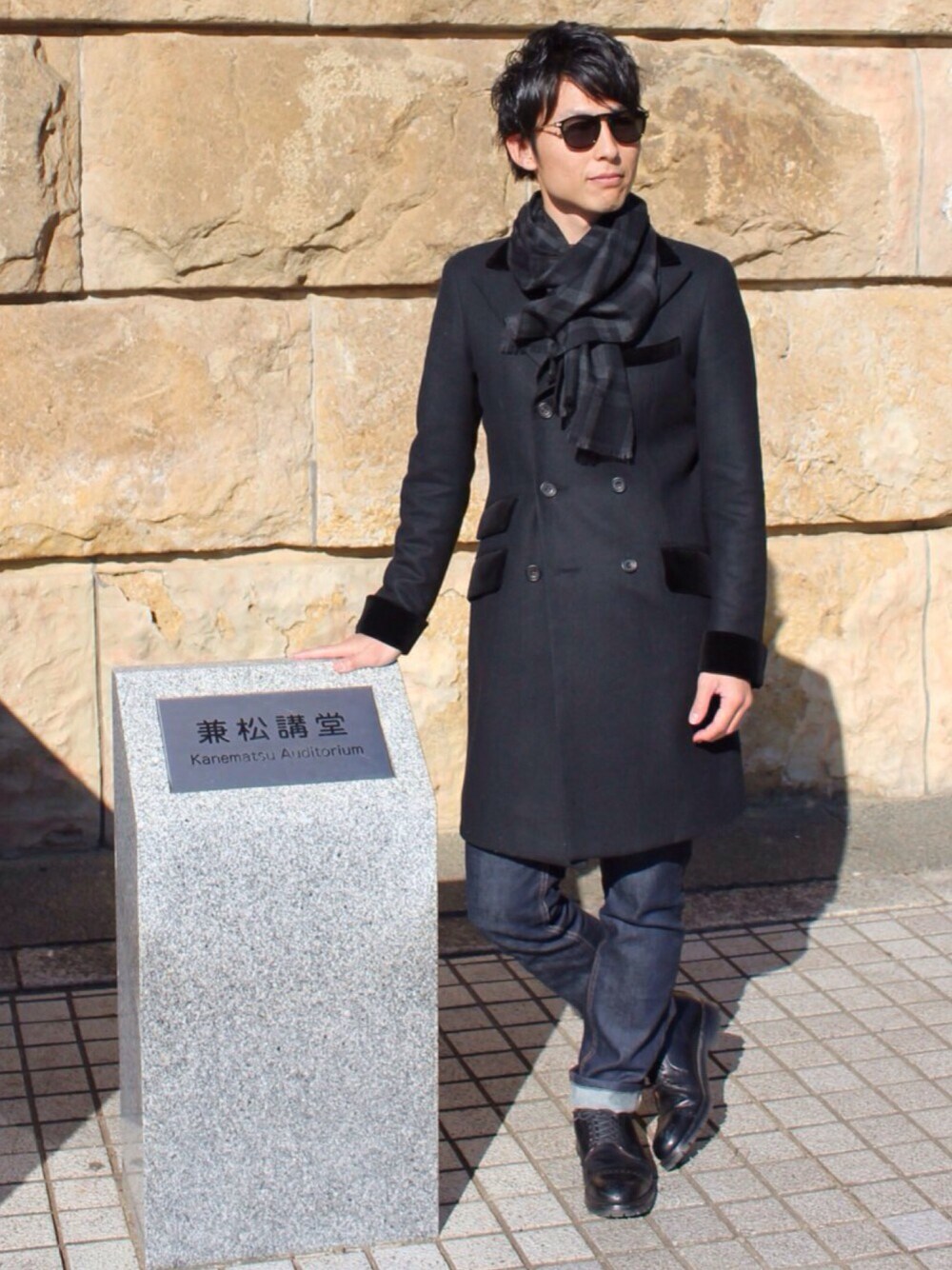 ブラック系のテーラードジャケット、ブラック系のドレスシューズ、ブルー系のデニムパンツを着用したメンズの冬コーディネートの1枚目の写真