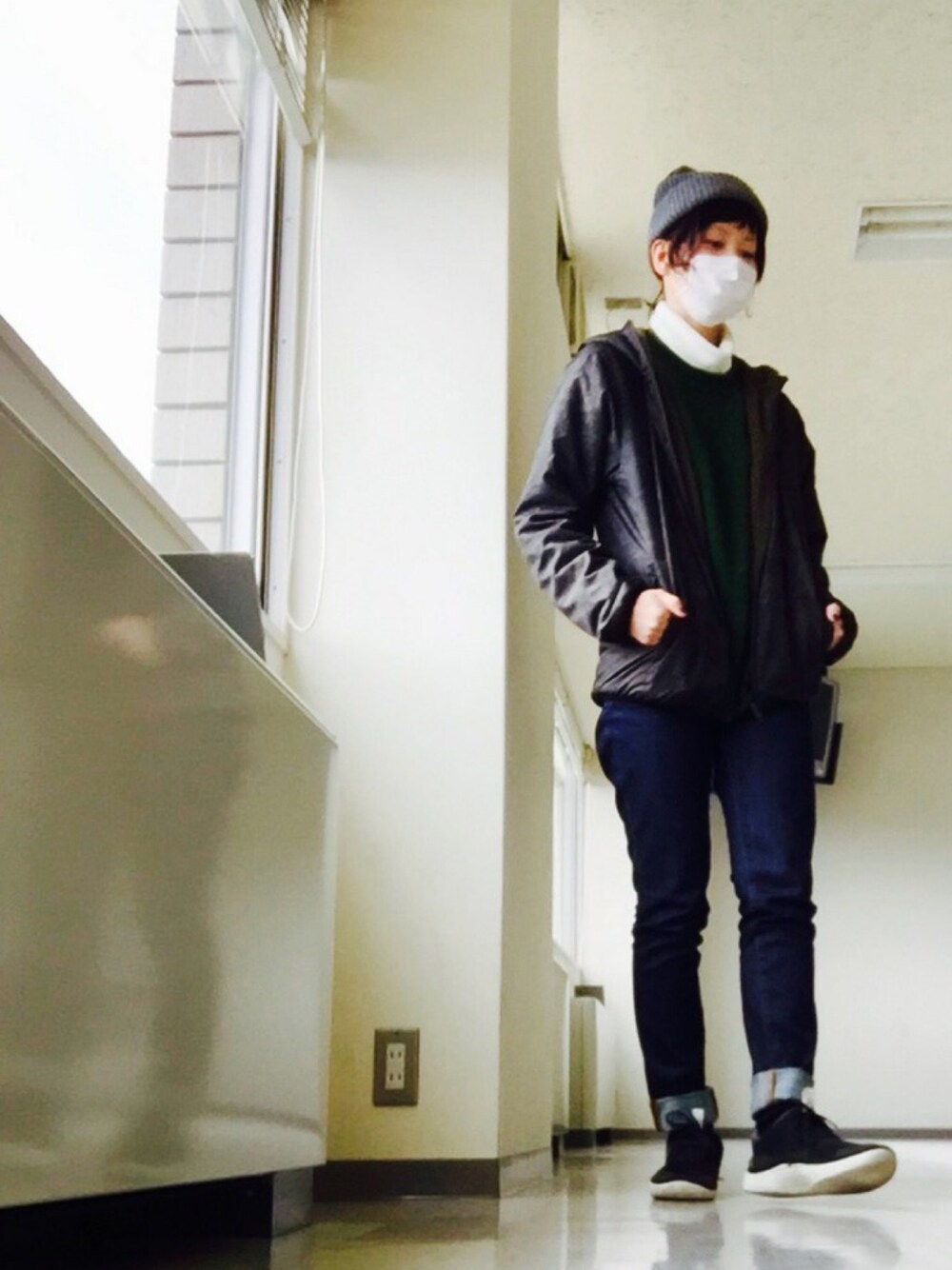 グレー系のニット/セーター、ブルー系のデニムパンツ、ブラック系のスニーカーを着用したレディースの冬コーディネートの1枚目の写真