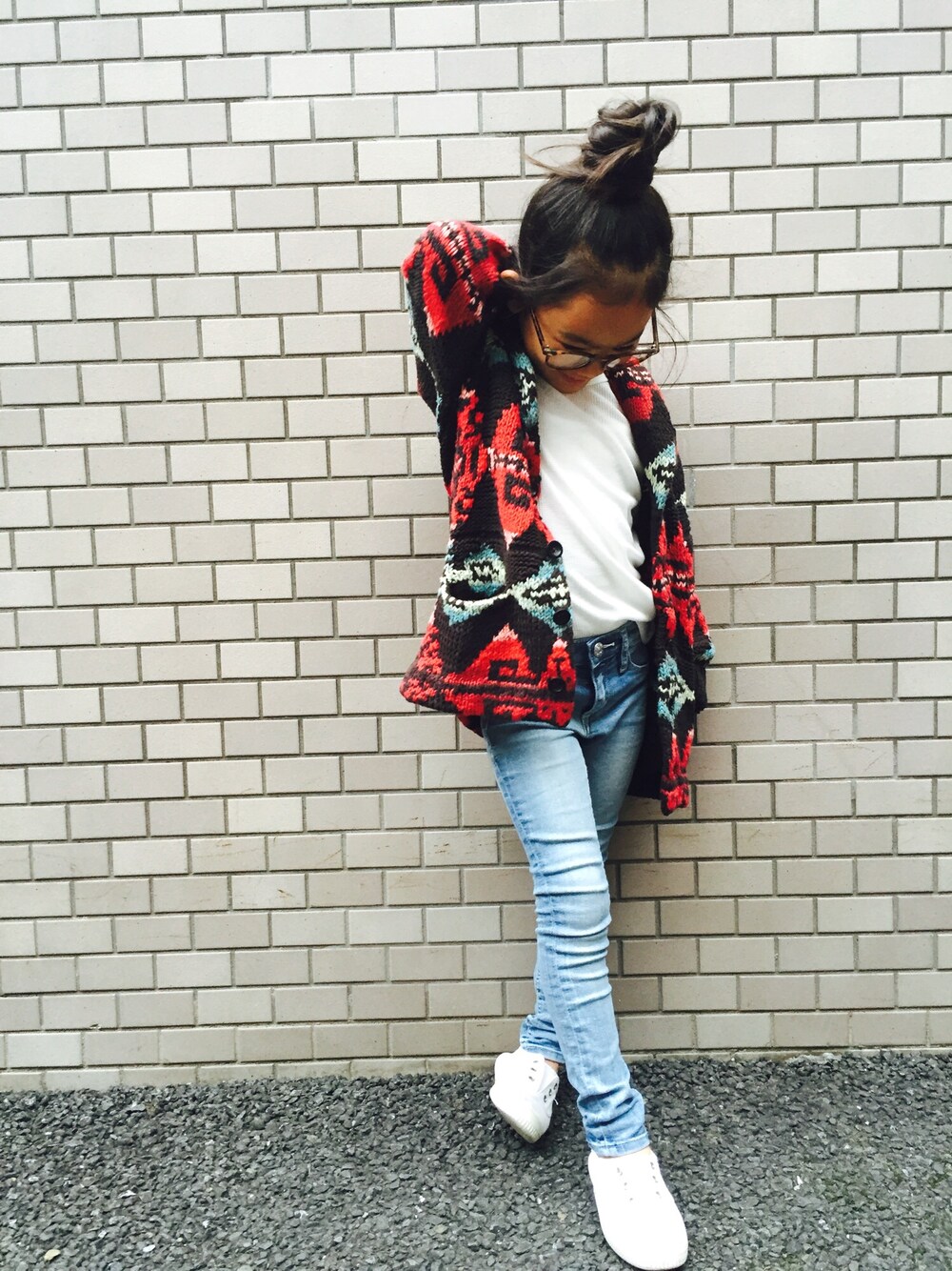 レッド系のカーディガン/ボレロ、ホワイト系のTシャツ/カットソー、ブルー系のデニムパンツを着用したキッズの秋コーディネートの1枚目の写真