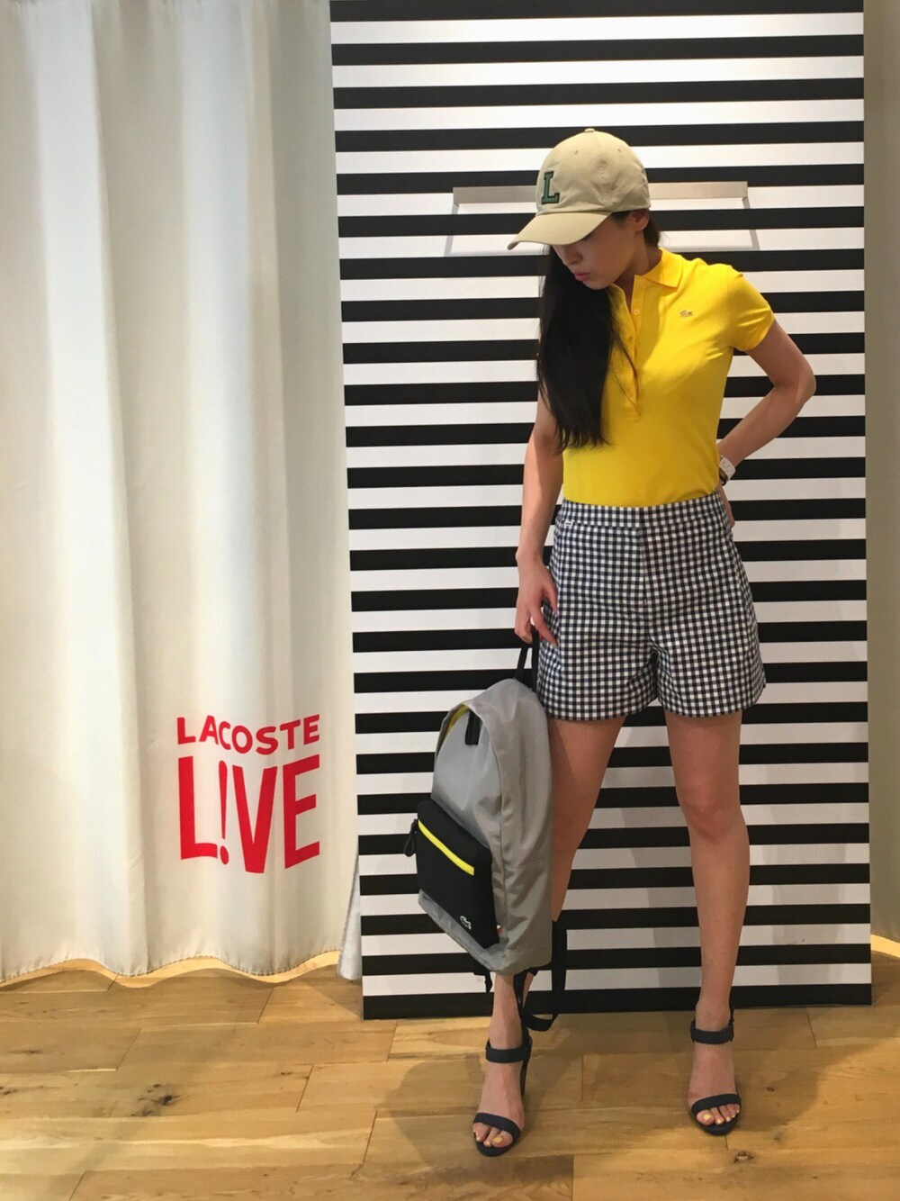 イエロー系のポロシャツ、ブルー系のその他パンツ、ブルー系のサンダルを着用したレディースの夏コーディネートの1枚目の写真