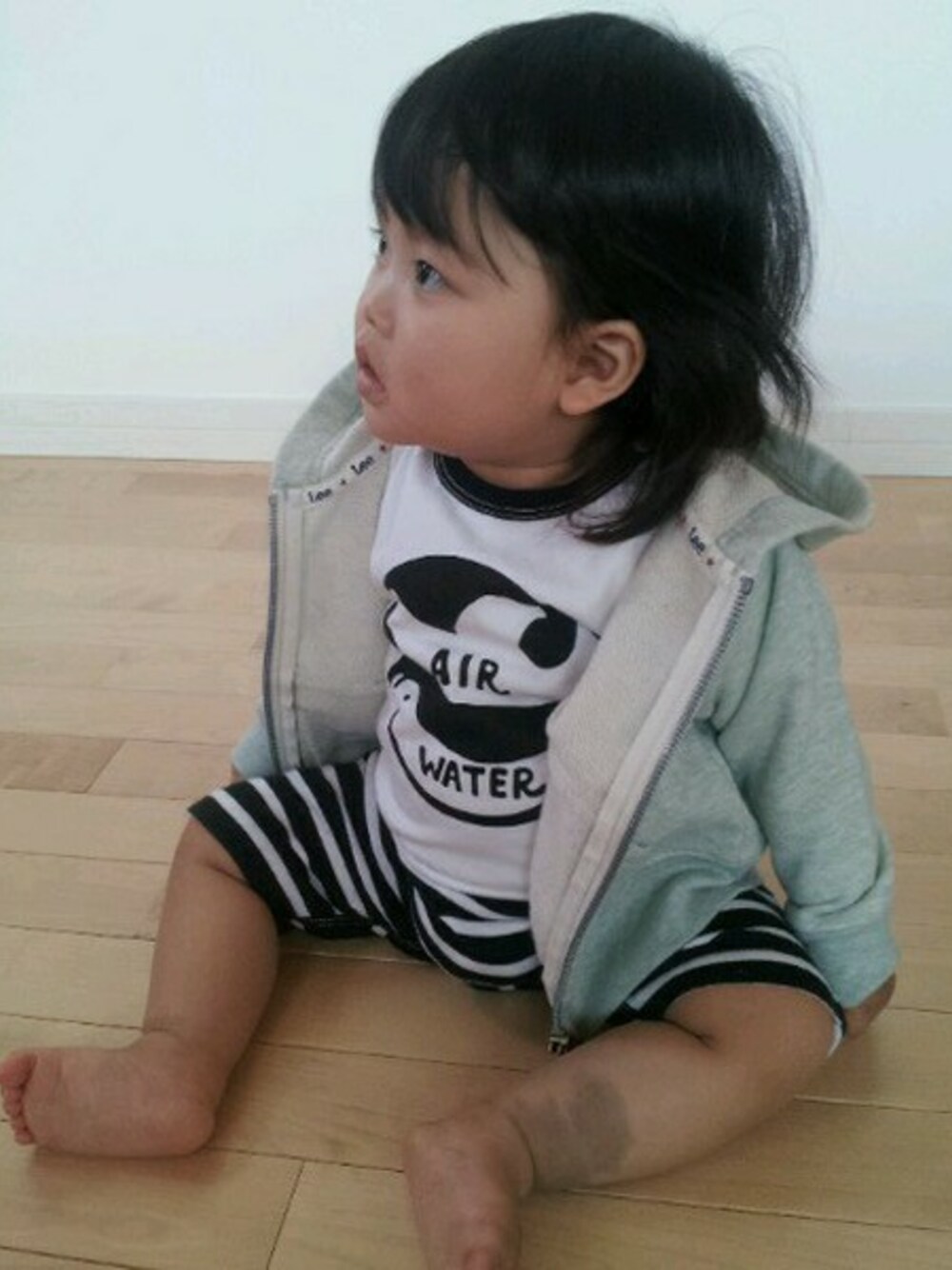 グリーン系のパーカー、ブラック系のロンパースを着用したキッズの春コーディネートの1枚目の写真