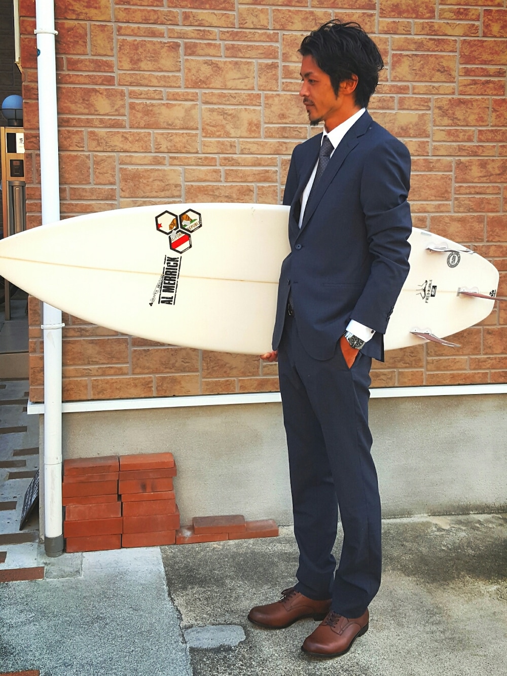 グレー系のネクタイ、ブルー系のスーツジャケット、ブラウン系のドレスシューズを着用したメンズの秋コーディネートの1枚目の写真