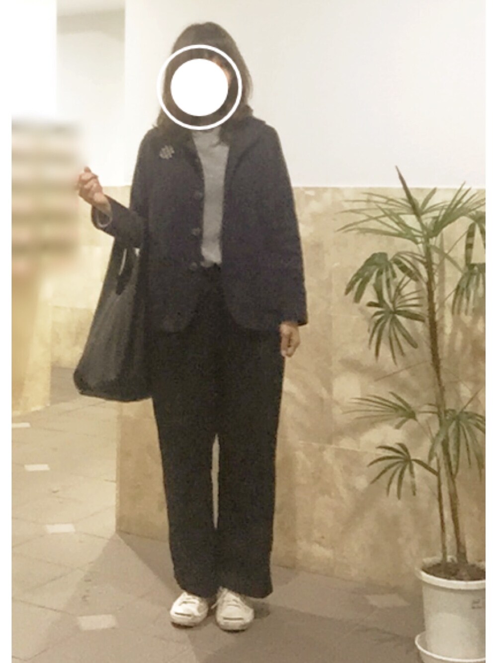 ホワイト系のスニーカー、ブラック系のパンツ、グレー系のニット/セーターを着用したレディースの冬コーディネートの1枚目の写真