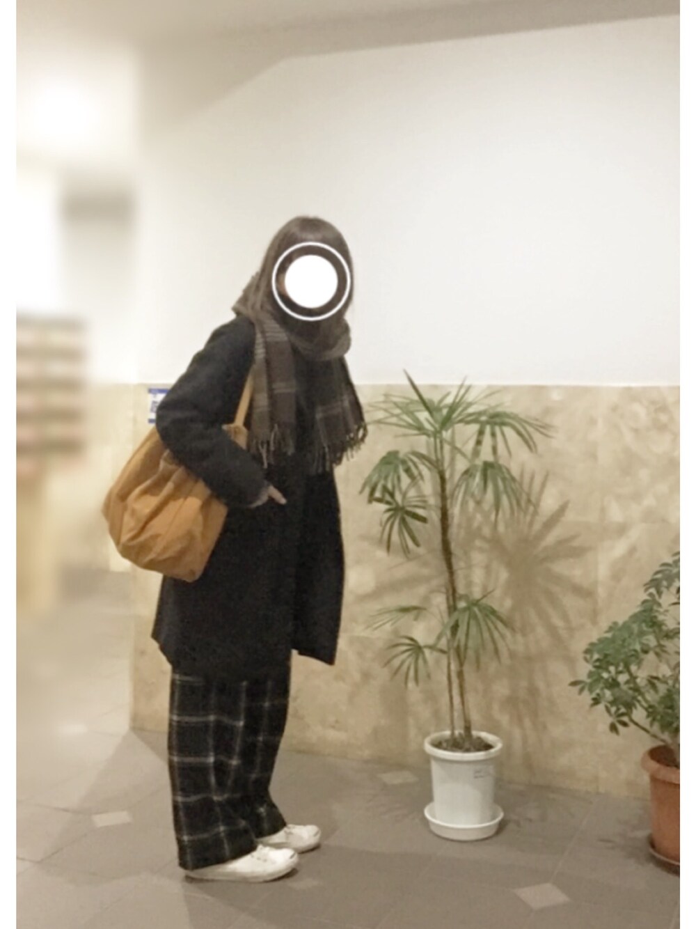 ホワイト系のスニーカー、グリーン系のその他パンツ、ブラック系のチェスターコートを着用したレディースの冬コーディネートの1枚目の写真