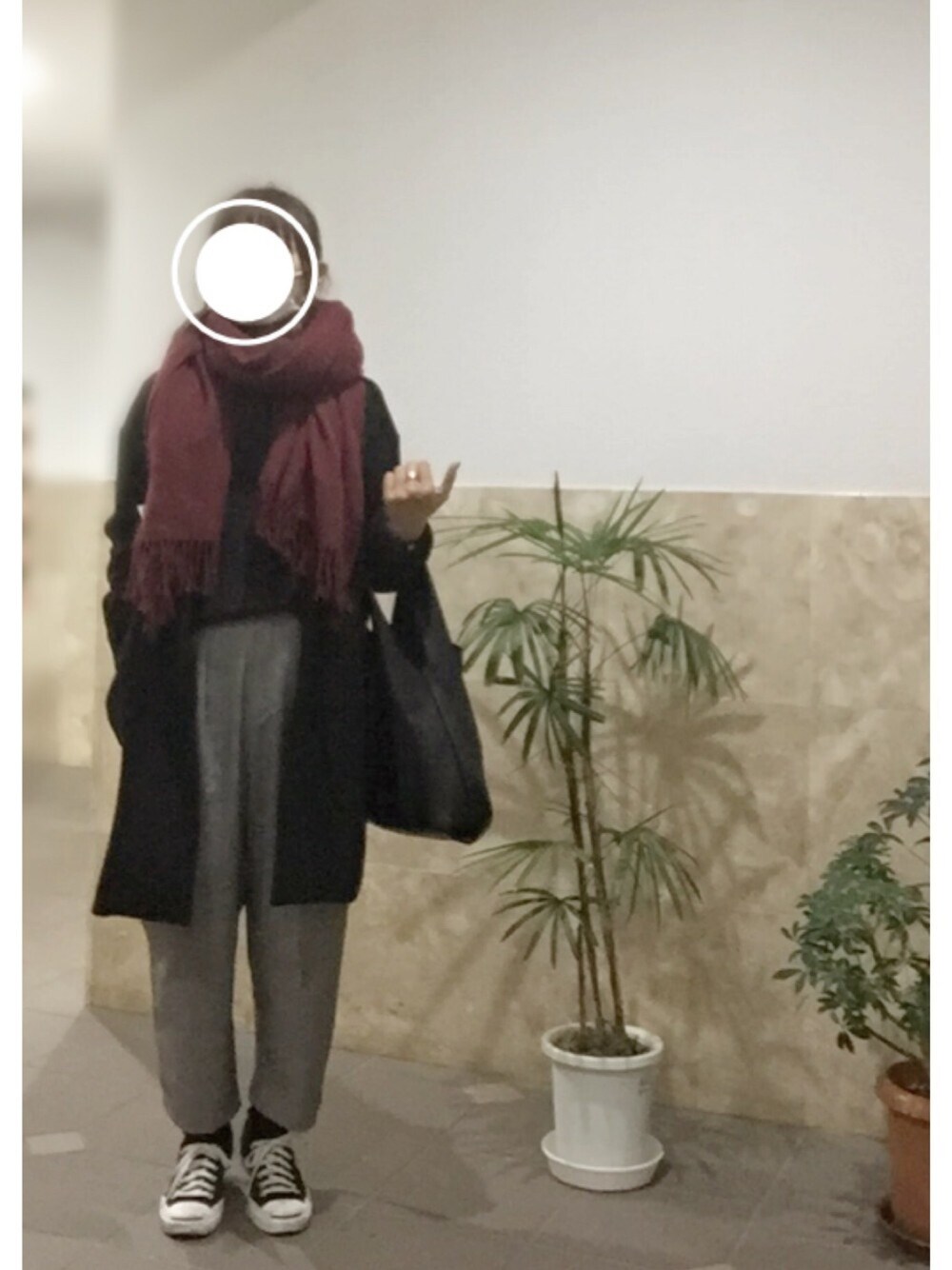 ブラック系のスニーカー、グレー系のパンツ、ブラック系のトートバッグを着用したレディースの冬コーディネートの1枚目の写真