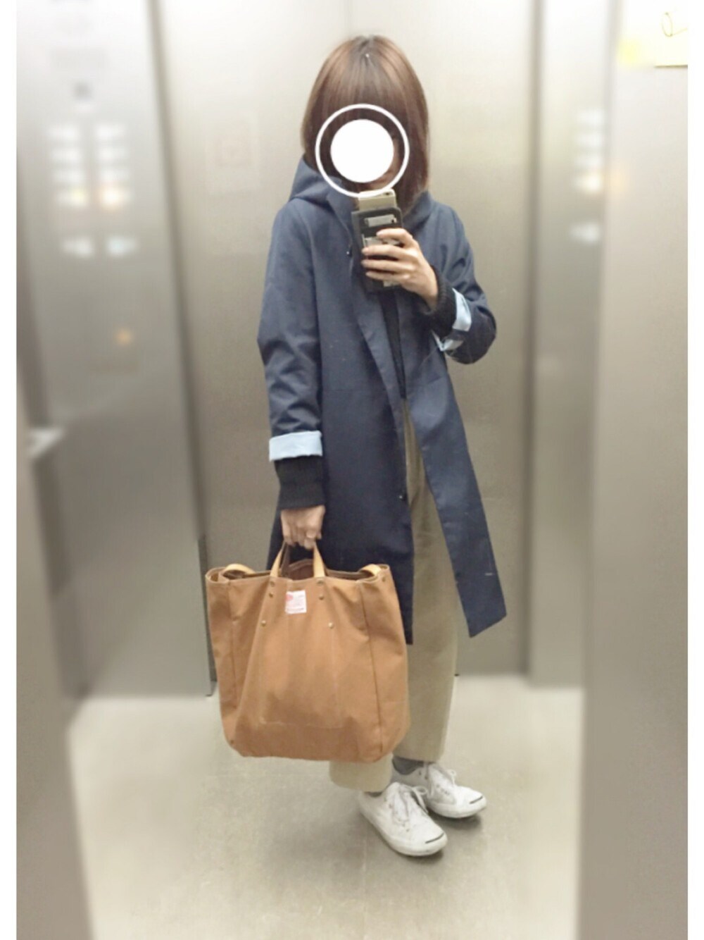 ホワイト系のスニーカー、ベージュ系のパンツ、ゴールド系のトートバッグを着用したレディースの春コーディネートの1枚目の写真