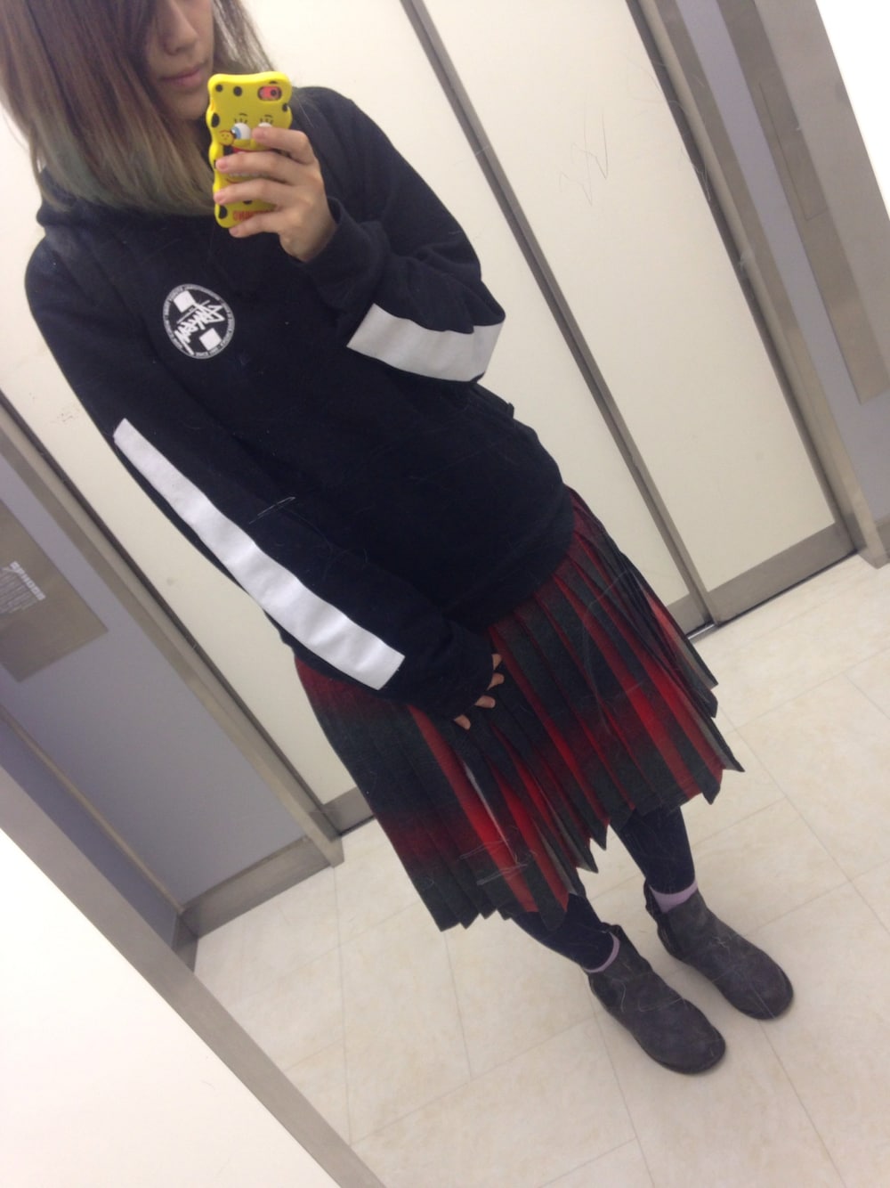 ブラック系のパーカー、レッド系のスカート、ブラック系のブーツを着用したレディースの春コーディネートの1枚目の写真