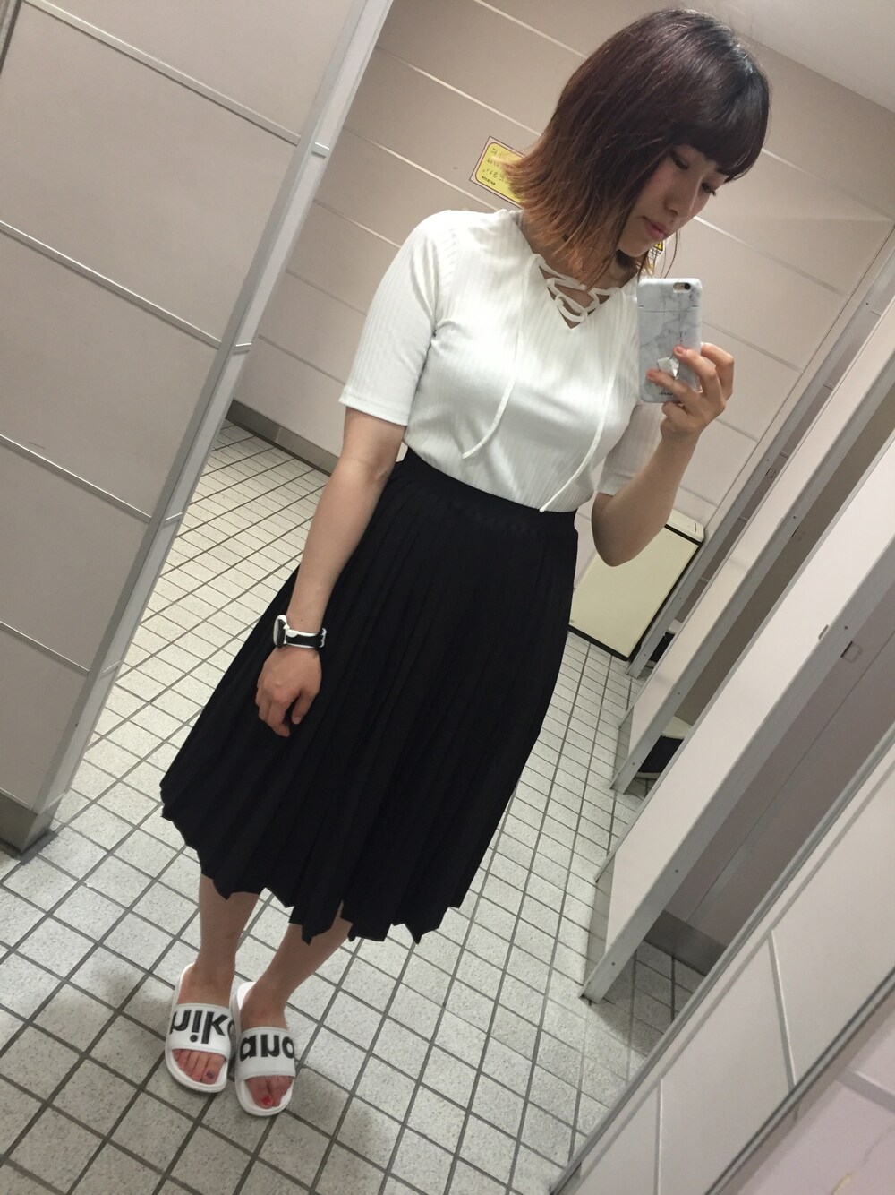 ホワイト系のTシャツ/カットソー、ブラック系のスカート、ホワイト系のサンダルを着用したレディースの夏コーディネートの1枚目の写真