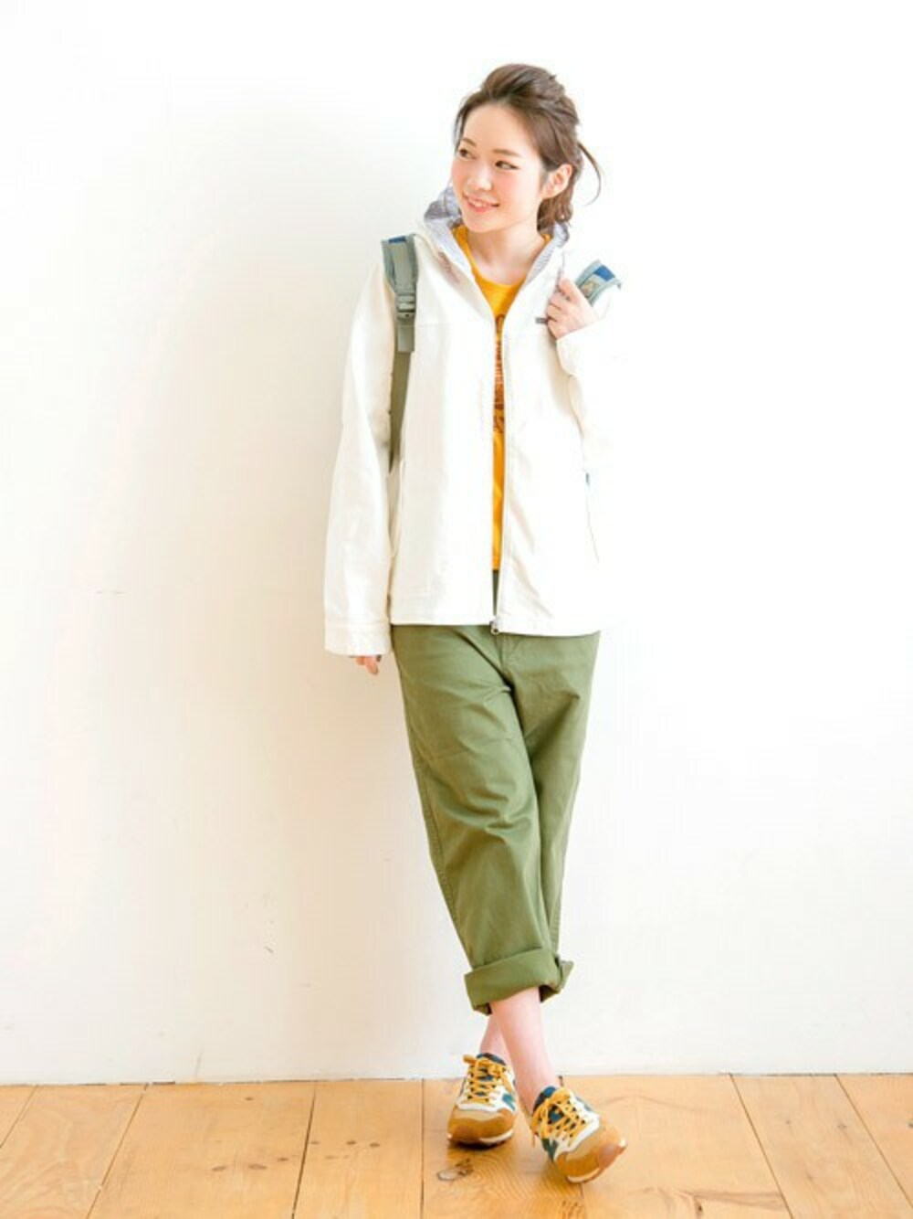 ホワイト系のマウンテンパーカー、グリーン系のチノパンツを着用したレディースの春コーディネートの1枚目の写真