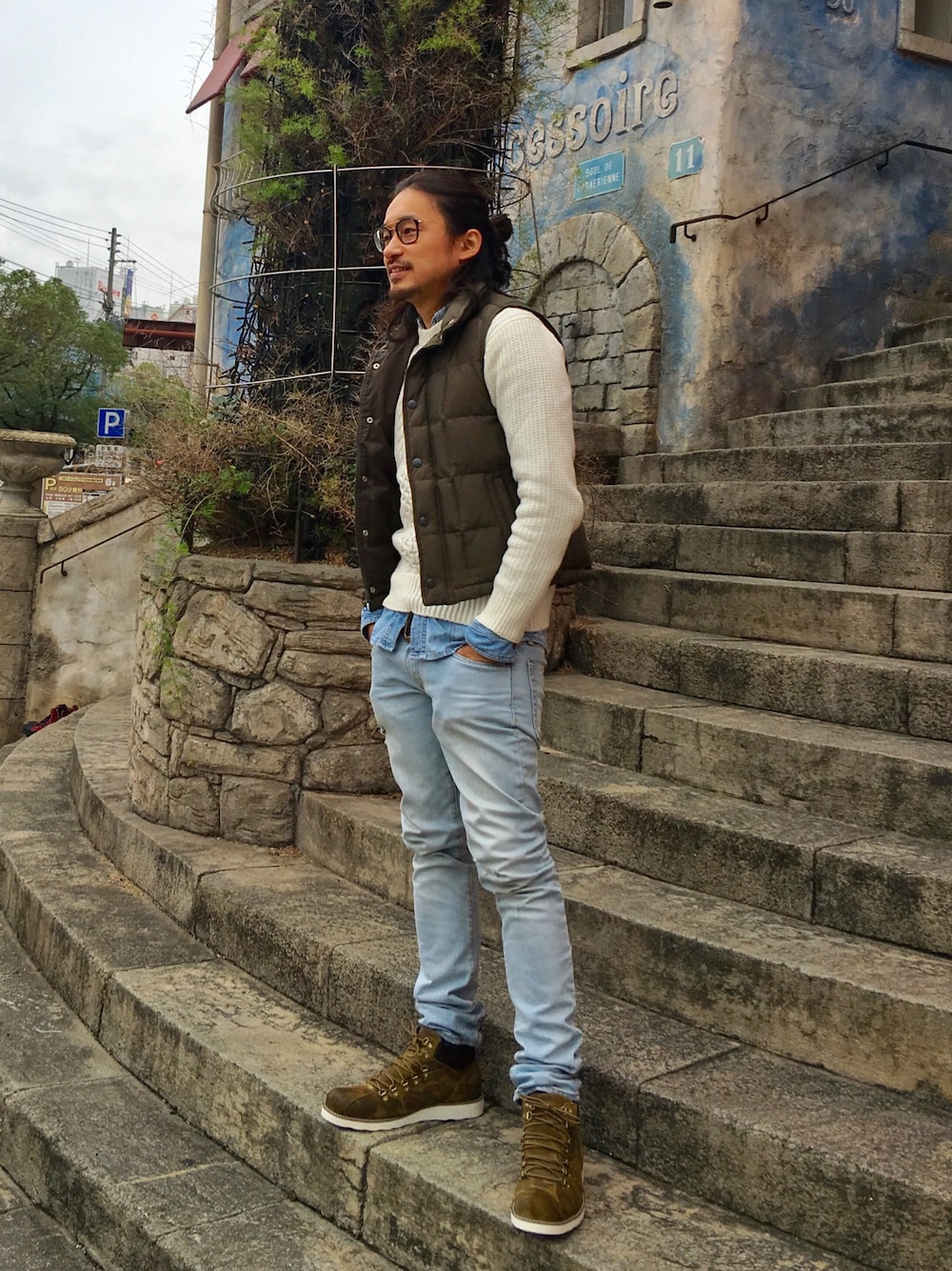 その他のブーツ、ブルー系のデニムパンツ、グリーン系のダウンベストを着用したメンズの秋コーディネートの1枚目の写真