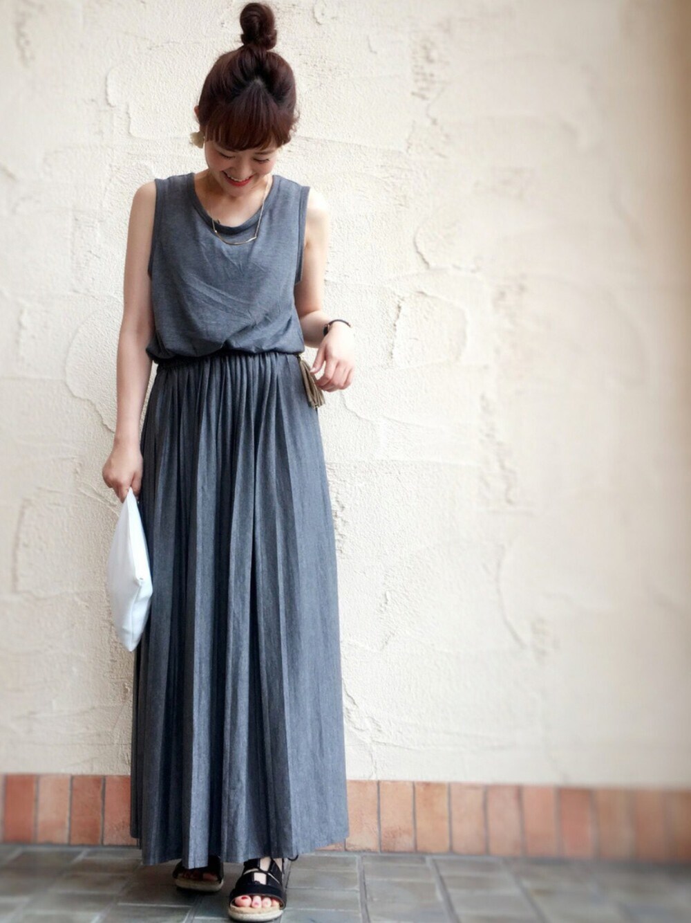 グレー系のワンピース、ブラック系のサンダル、ベージュ系のネックレスを着用したレディースの夏コーディネートの1枚目の写真