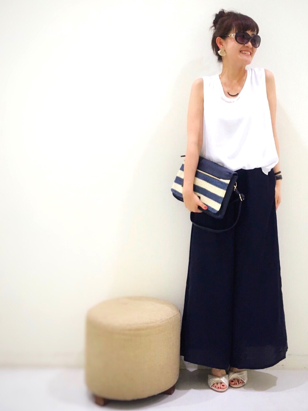 ブルー系のショルダーバッグ、ホワイト系のサロペット/オーバーオール、ゴールド系のサンダルを着用したレディースの夏コーディネートの1枚目の写真