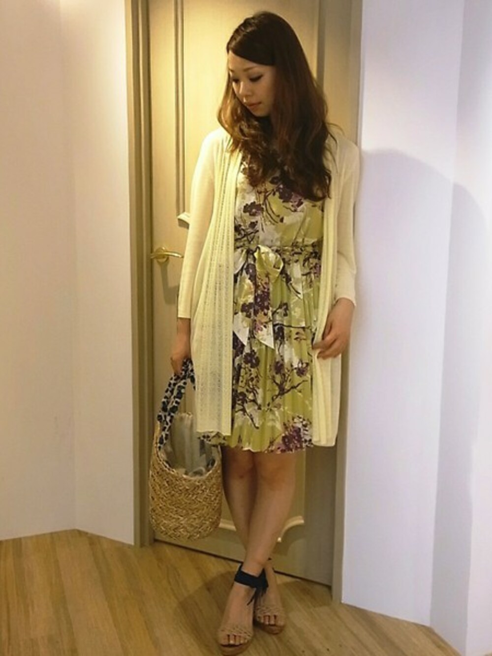 イエロー系のワンピース、イエロー系のカーディガン/ボレロ、ベージュ系のかごバッグを着用したレディースの春コーディネートの1枚目の写真