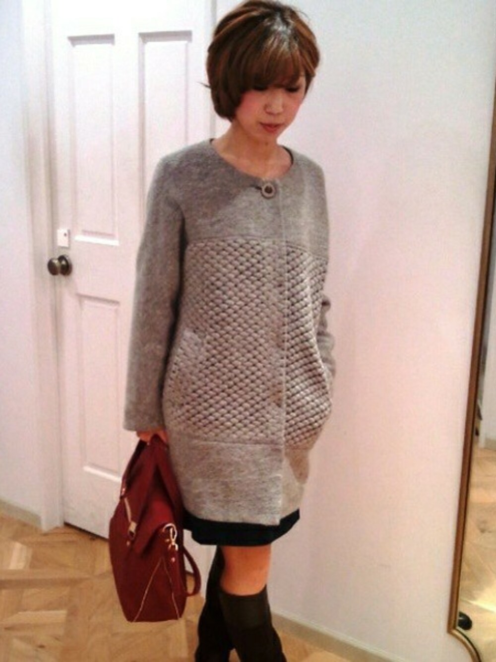 グレー系のその他アウター、グリーン系のワンピース、レッド系のハンドバッグを着用したレディースの秋コーディネートの1枚目の写真