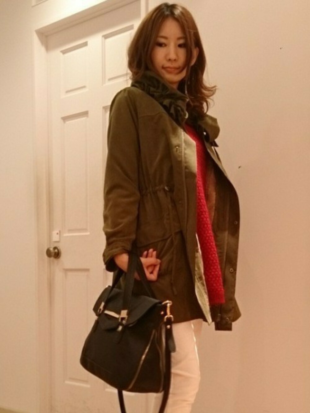 ブラック系のハンドバッグ、ベージュ系のスラックス、グリーン系のモッズコートを着用したレディースの秋コーディネートの1枚目の写真