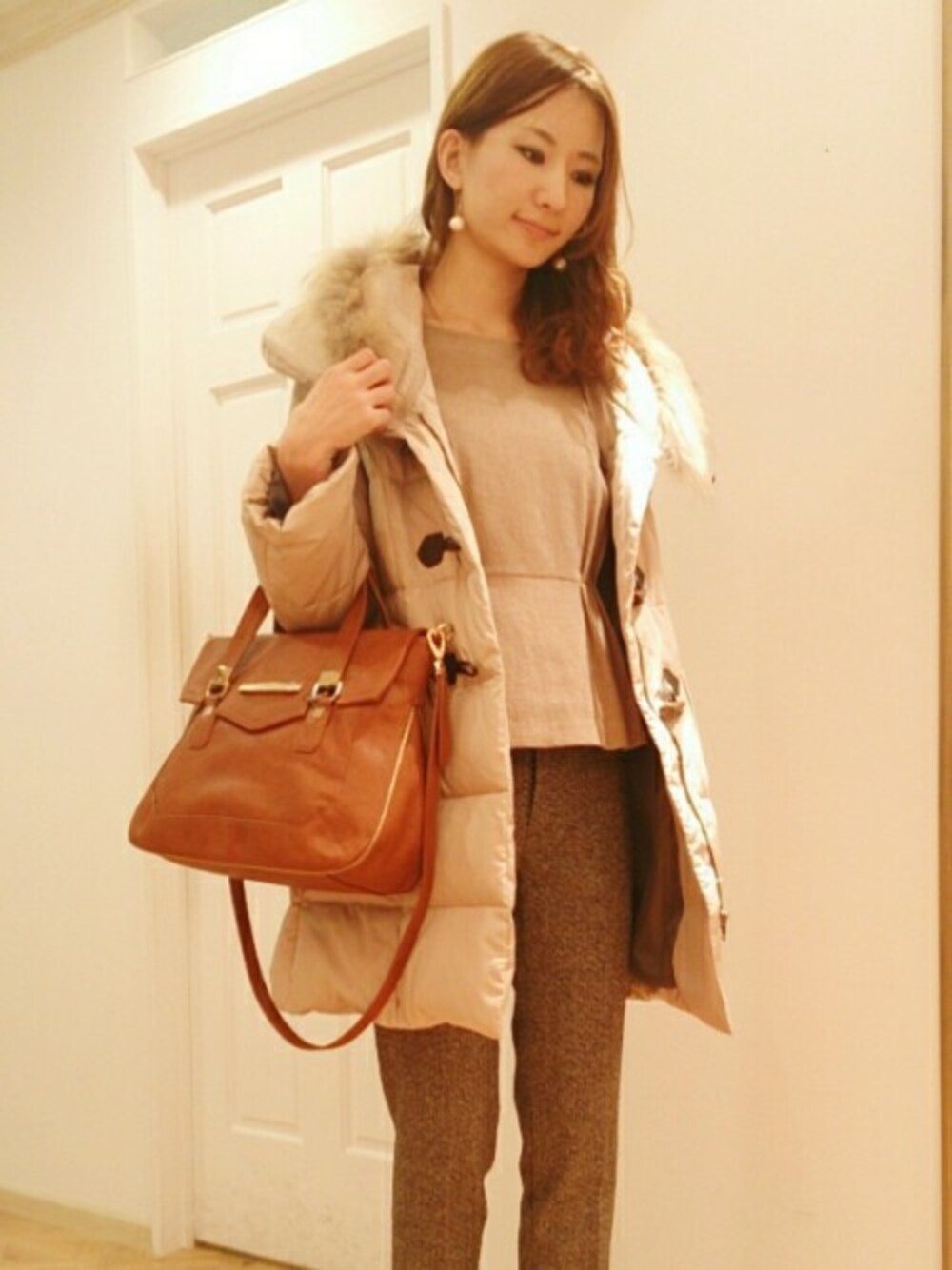 イエロー系のダウンジャケット/コート、ベージュ系のシャツ/ブラウス、ブラウン系のスラックスを着用したレディースの秋コーディネートの1枚目の写真