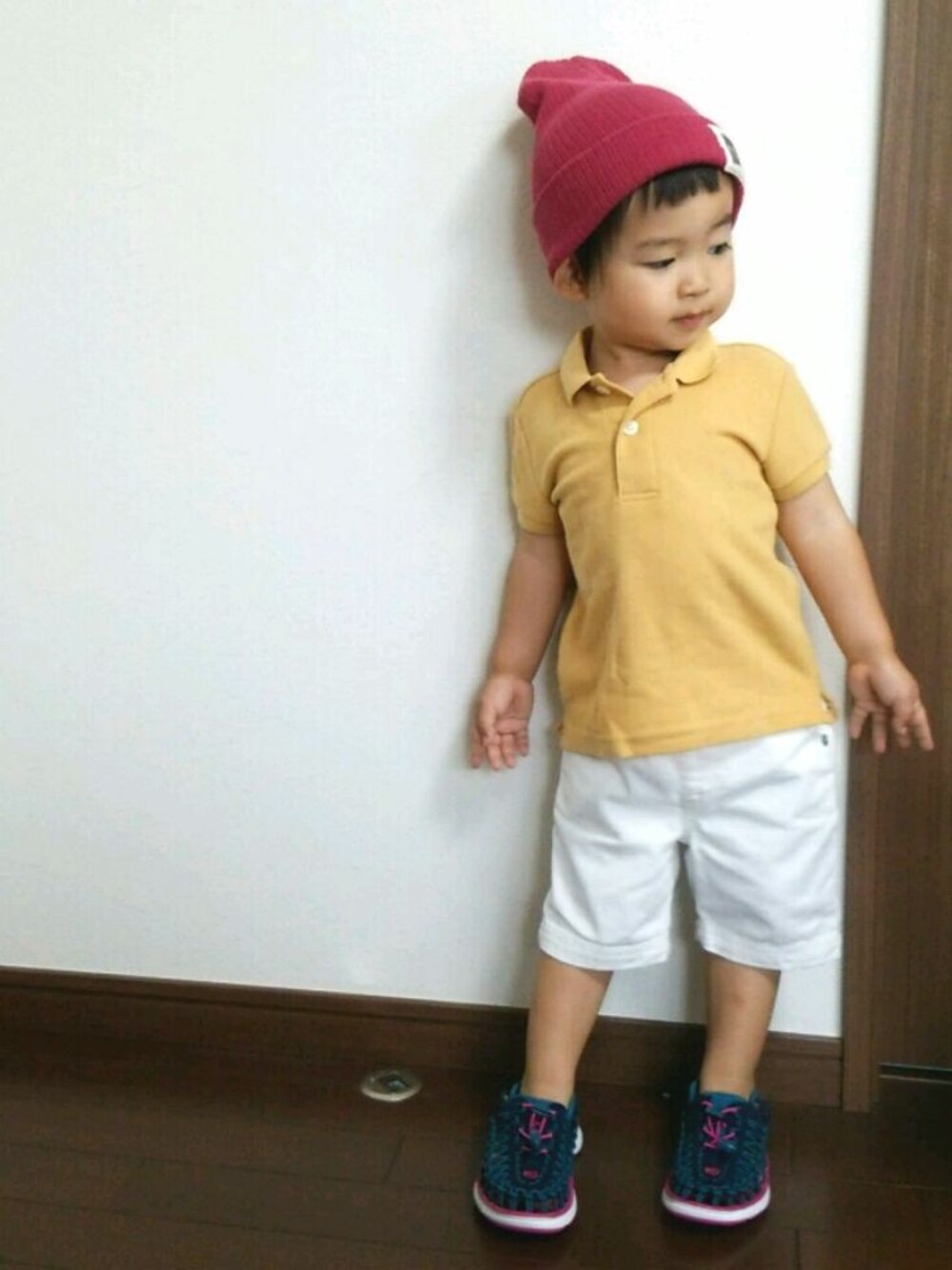 イエロー系のポロシャツ、ホワイト系のその他パンツ、ブルー系のスニーカーを着用したキッズの夏コーディネートの1枚目の写真