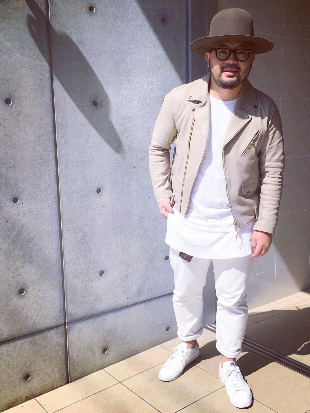 ベージュ系のライダースジャケット、ホワイト系のTシャツ/カットソー、ホワイト系のスニーカーを着用したメンズの春コーディネートの1枚目の写真