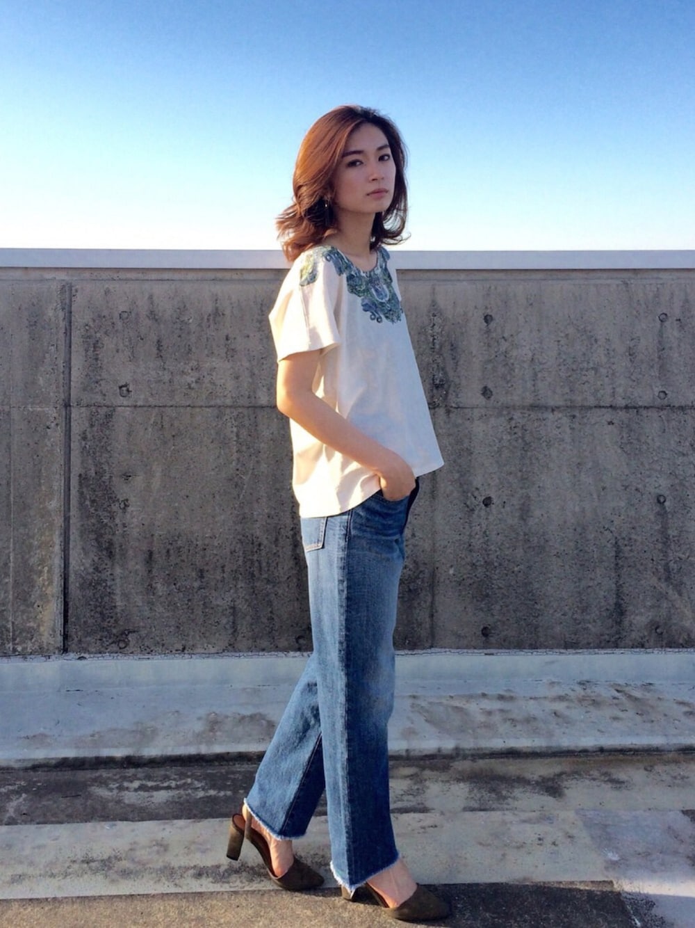 ホワイト系のTシャツ/カットソー、ブルー系のデニムパンツ、グリーン系のパンプスを着用したレディースの春コーディネートの1枚目の写真