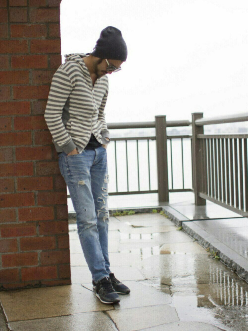 グレー系のパーカー、ブルー系のパンツ、ブラック系のスニーカーを着用したメンズの春コーディネートの1枚目の写真