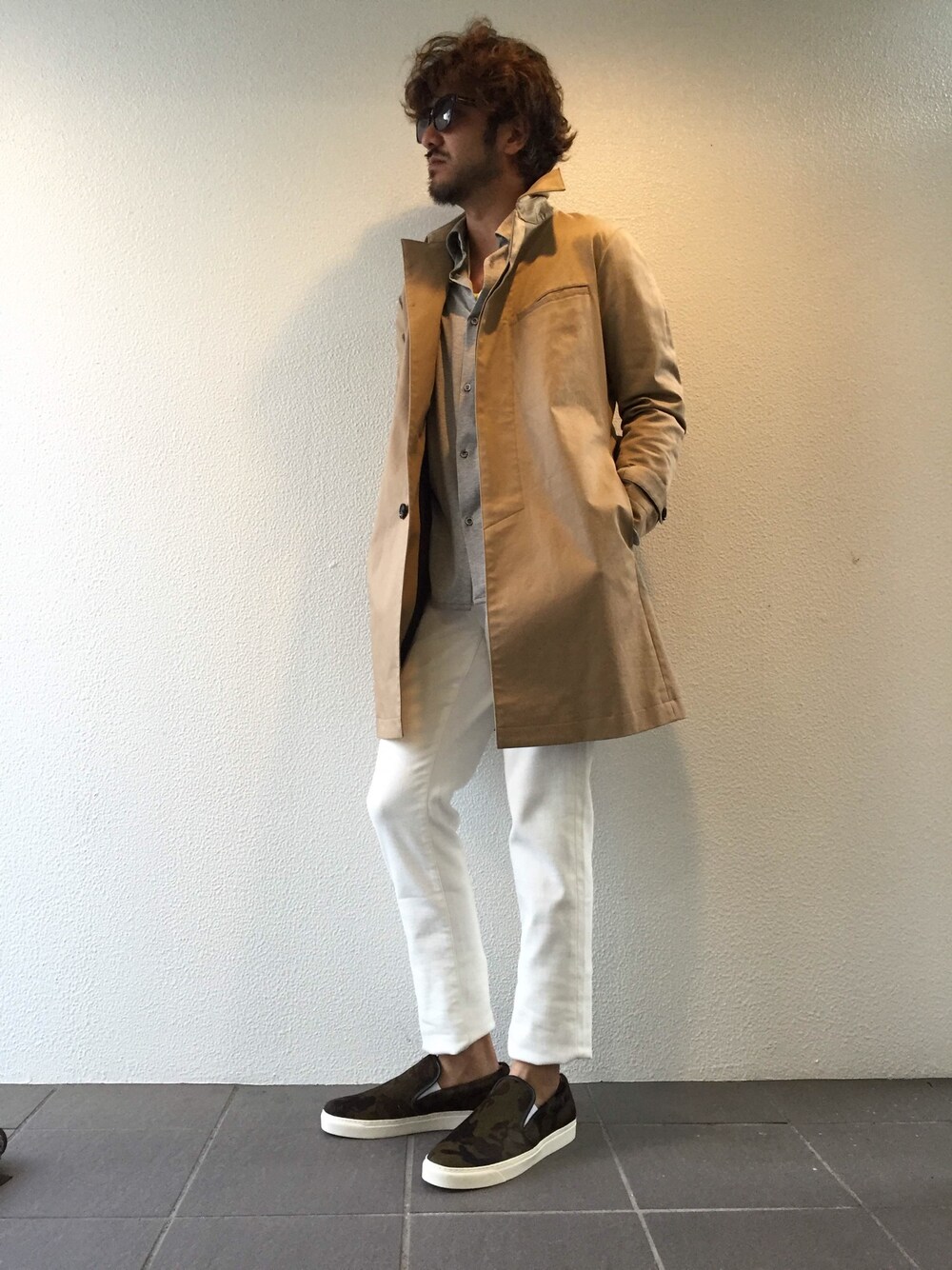 グレー系のシャツ/ブラウス、ベージュ系のトレンチコート、ホワイト系のパンツを着用したメンズの春コーディネートの1枚目の写真