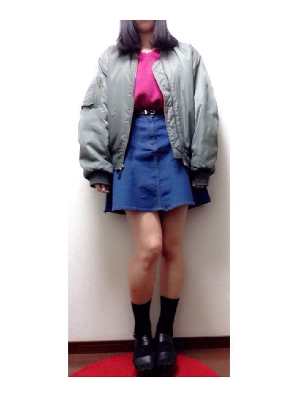 ピンク系のニット/セーター、グリーン系のブルゾン、ブルー系のデニムスカートを着用したレディースの冬コーディネートの1枚目の写真