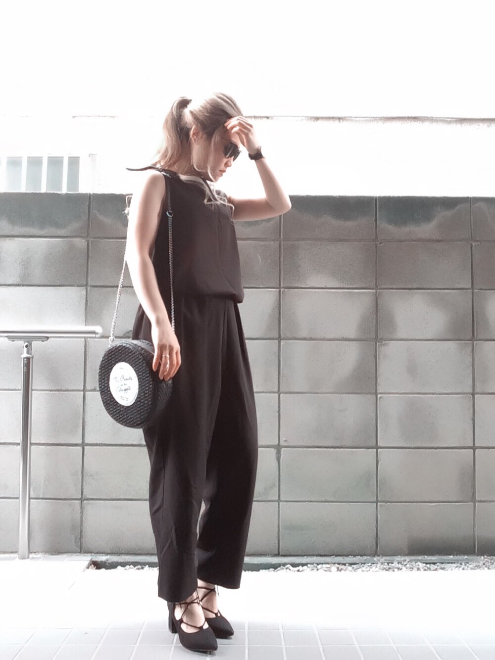 ブラック系のパンプス、ブラック系のつなぎ/オールインワン、ブラック系のショルダーバッグを着用したレディースの春コーディネートの1枚目の写真