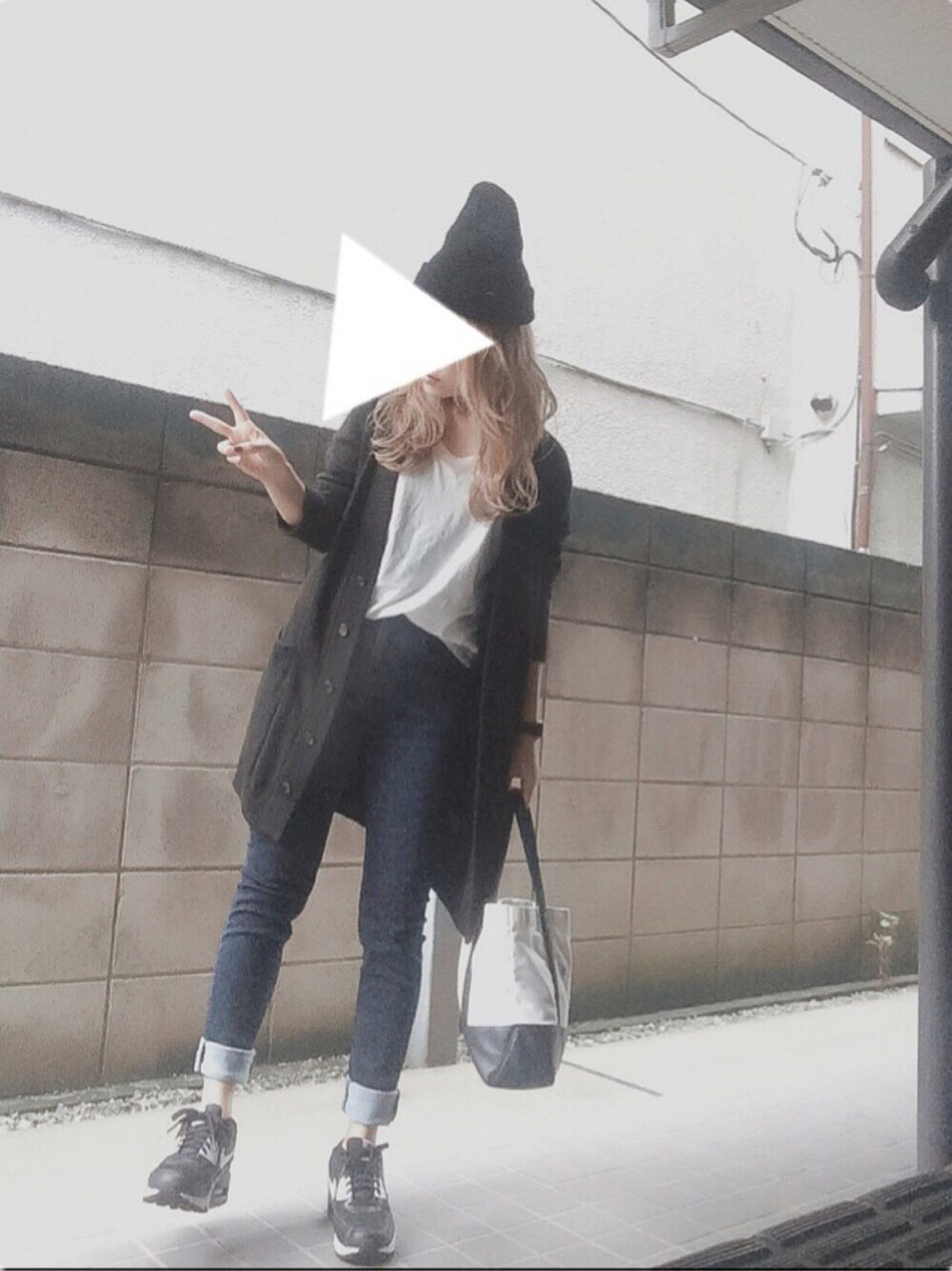 ブラック系のスニーカー、ホワイト系のエコバッグ/サブバッグ、ブルー系のデニムパンツを着用したレディースの秋コーディネートの1枚目の写真