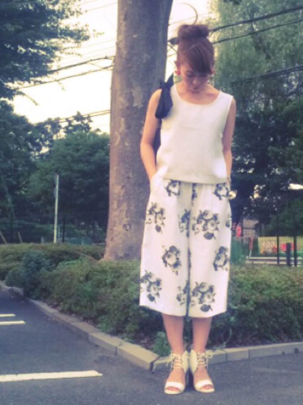 ホワイト系のタンクトップ、その他のパンツ、ホワイト系のサンダルを着用したレディースの夏コーディネートの1枚目の写真