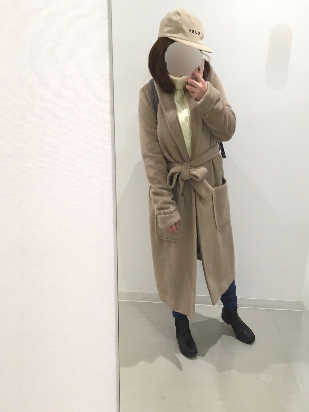 ホワイト系のニット/セーター、ベージュ系のその他アウター、ブラック系のブーツを着用したレディースの秋コーディネートの1枚目の写真