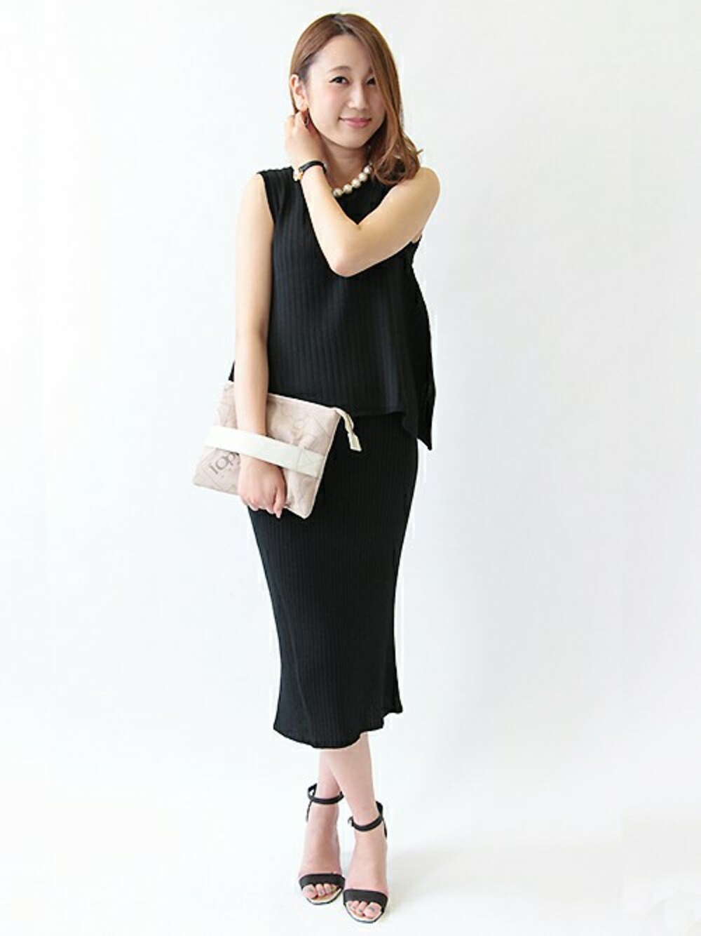 ブラック系のニット/セーター、ブラック系のスカートを着用したレディースの夏コーディネートの1枚目の写真