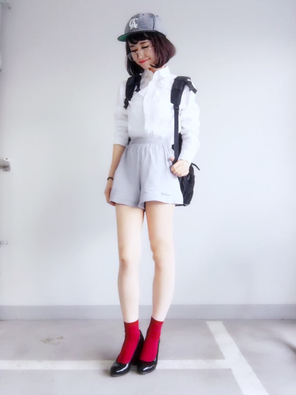 ブラック系のバックパック/リュック、ホワイト系のシャツ/ブラウス、グレー系のその他パンツを着用したレディースの秋コーディネートの1枚目の写真