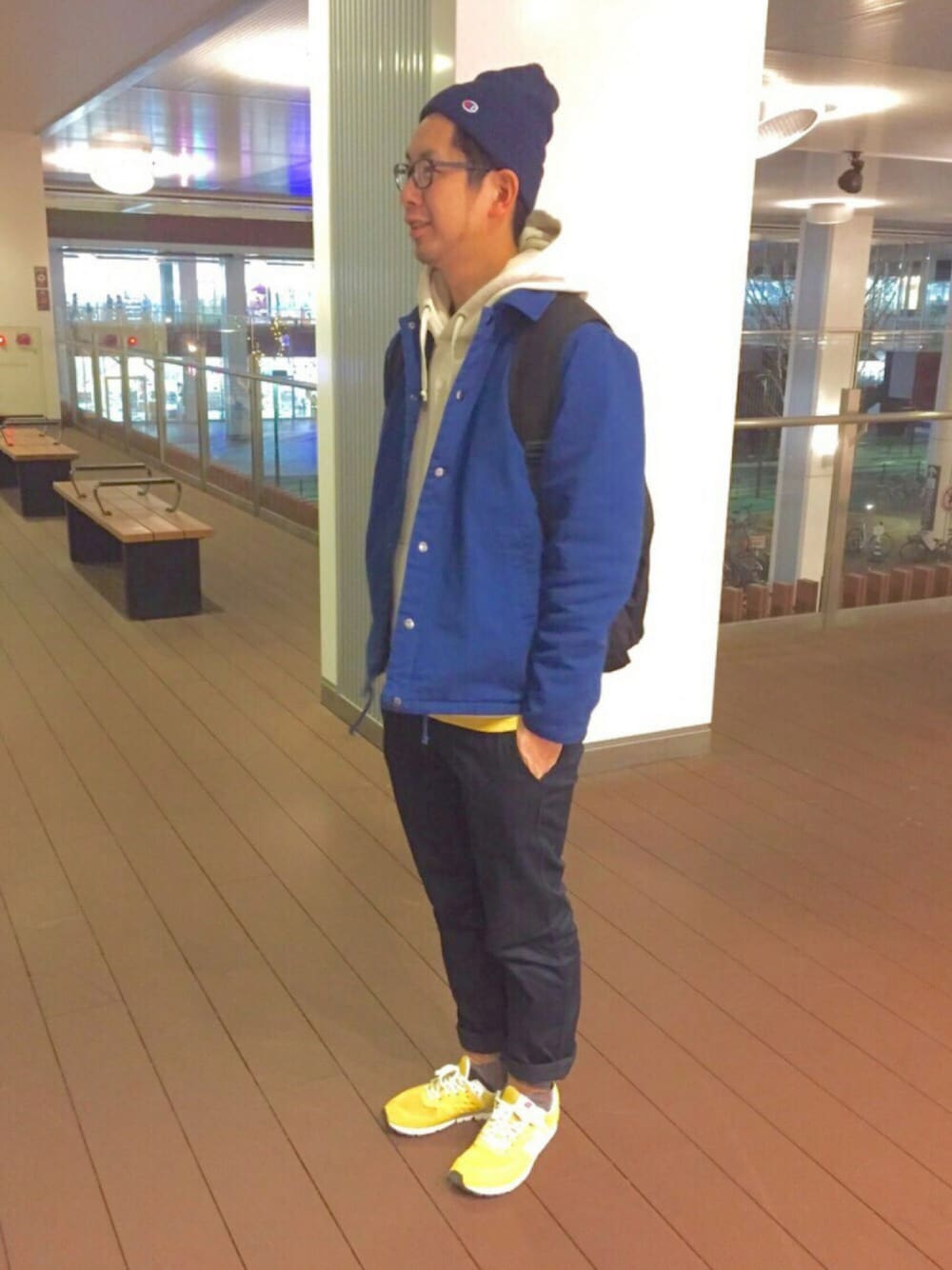 イエロー系のスニーカー、ブラック系のバックパック/リュック、ブルー系のテーラードジャケットを着用したメンズの冬コーディネートの1枚目の写真