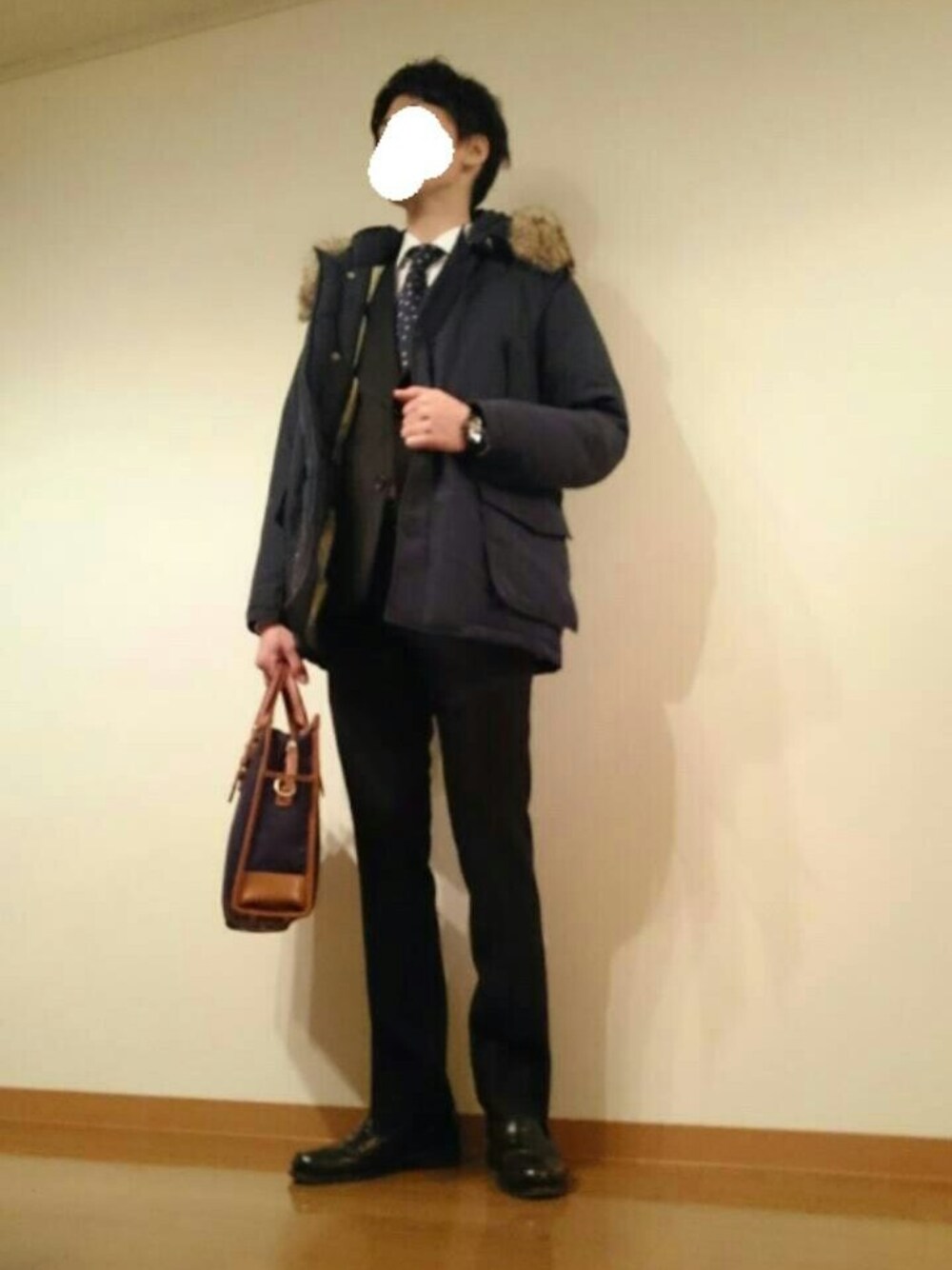 ブルー系のビジネスバッグ、ブルー系のネクタイ、ブラック系のローファーを着用したメンズの冬コーディネートの1枚目の写真