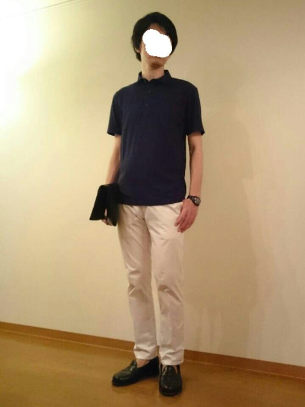 ブルー系のポロシャツ、ブラック系のクラッチバッグ、ホワイト系のチノパンツを着用したメンズの夏コーディネートの1枚目の写真