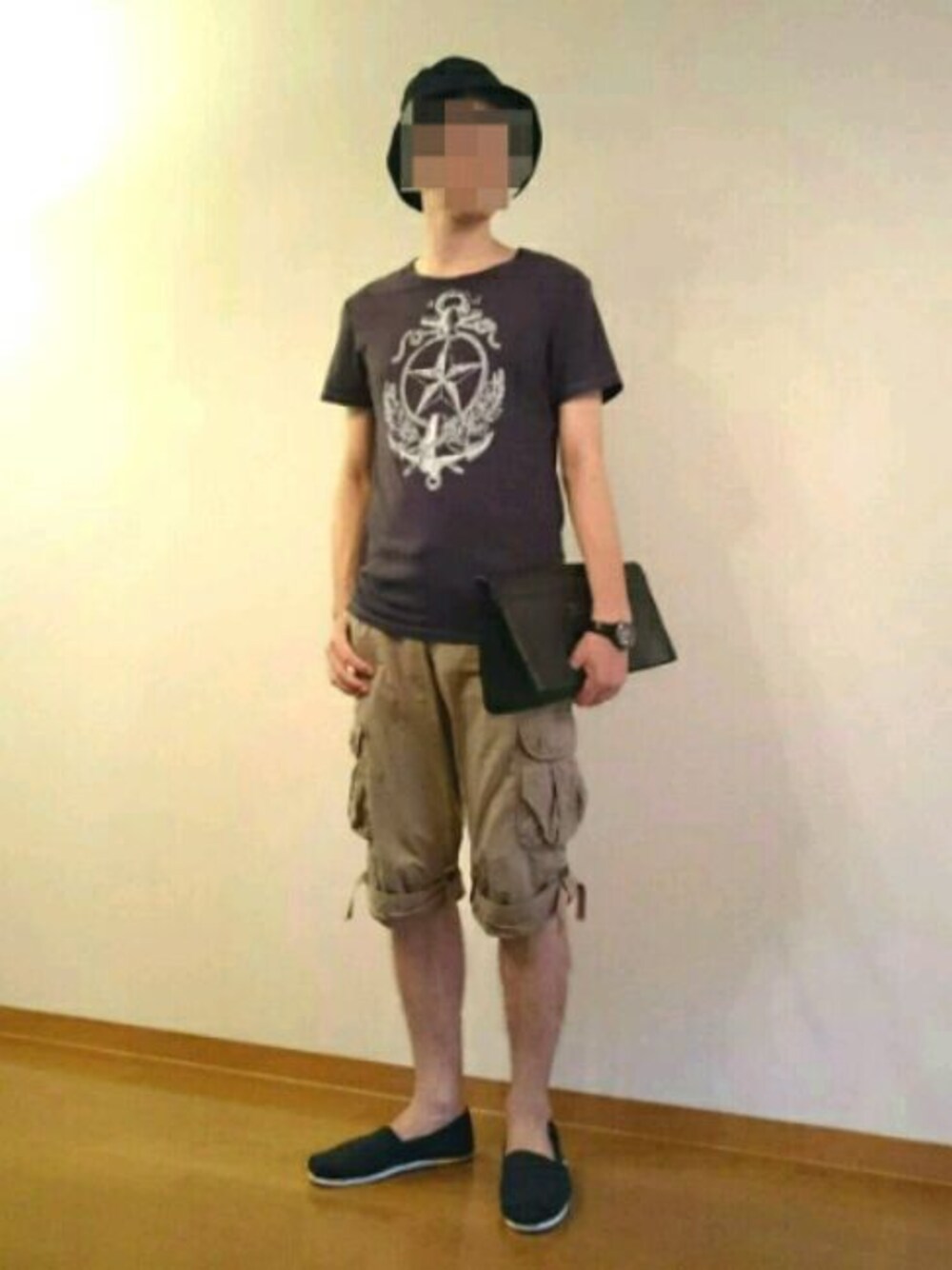 ブルー系のTシャツ/カットソー、ベージュ系のカーゴパンツ、ブラック系のクラッチバッグを着用したメンズの夏コーディネートの1枚目の写真