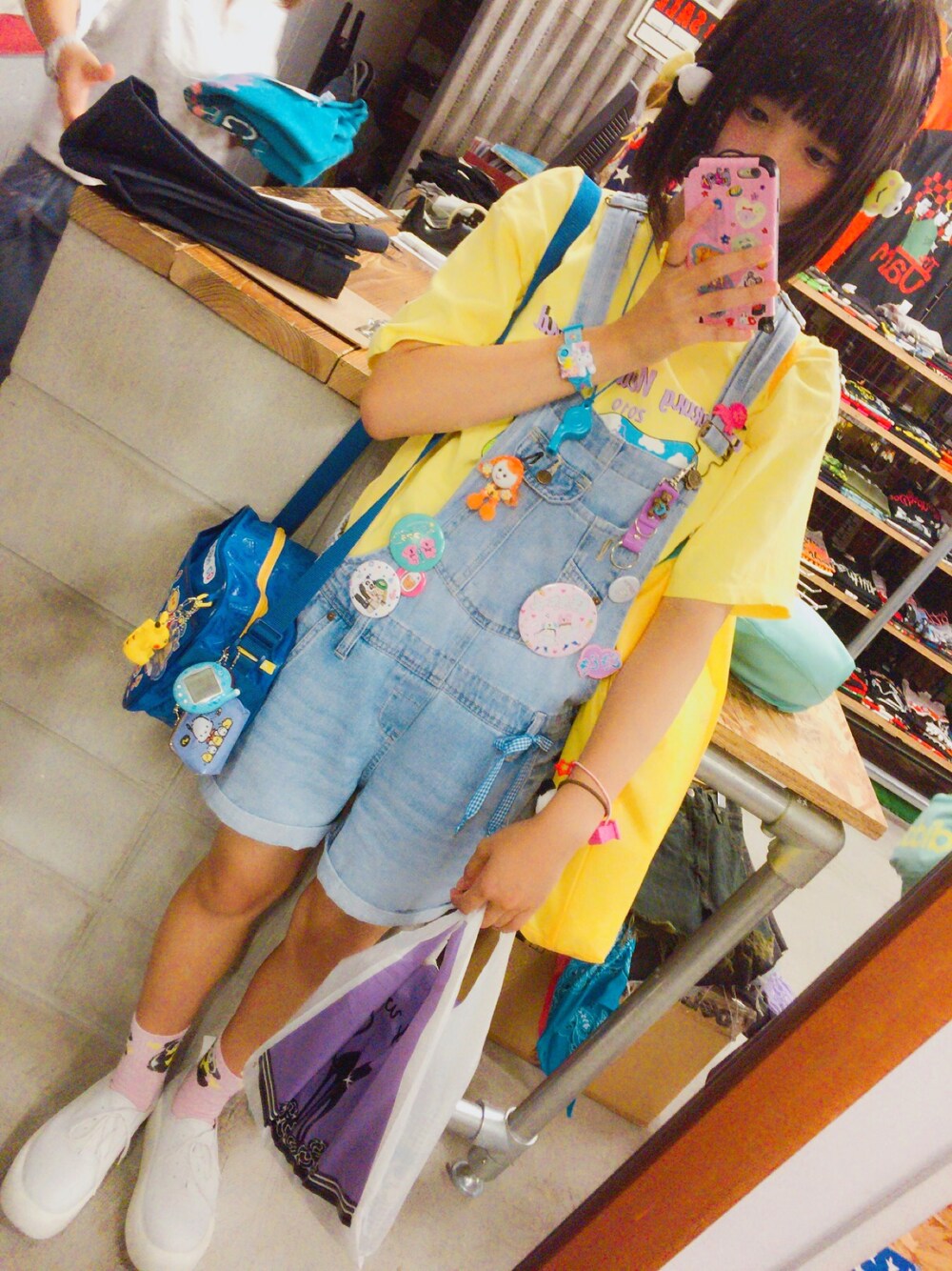 ブルー系のサロペット/オーバーオール、イエロー系のTシャツ/カットソー、ブルー系のショルダーバッグを着用したレディースの夏コーディネートの1枚目の写真