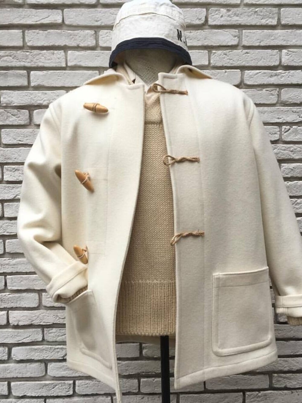 ホワイト系のダッフルコートを着用したメンズの冬コーディネートの1枚目の写真