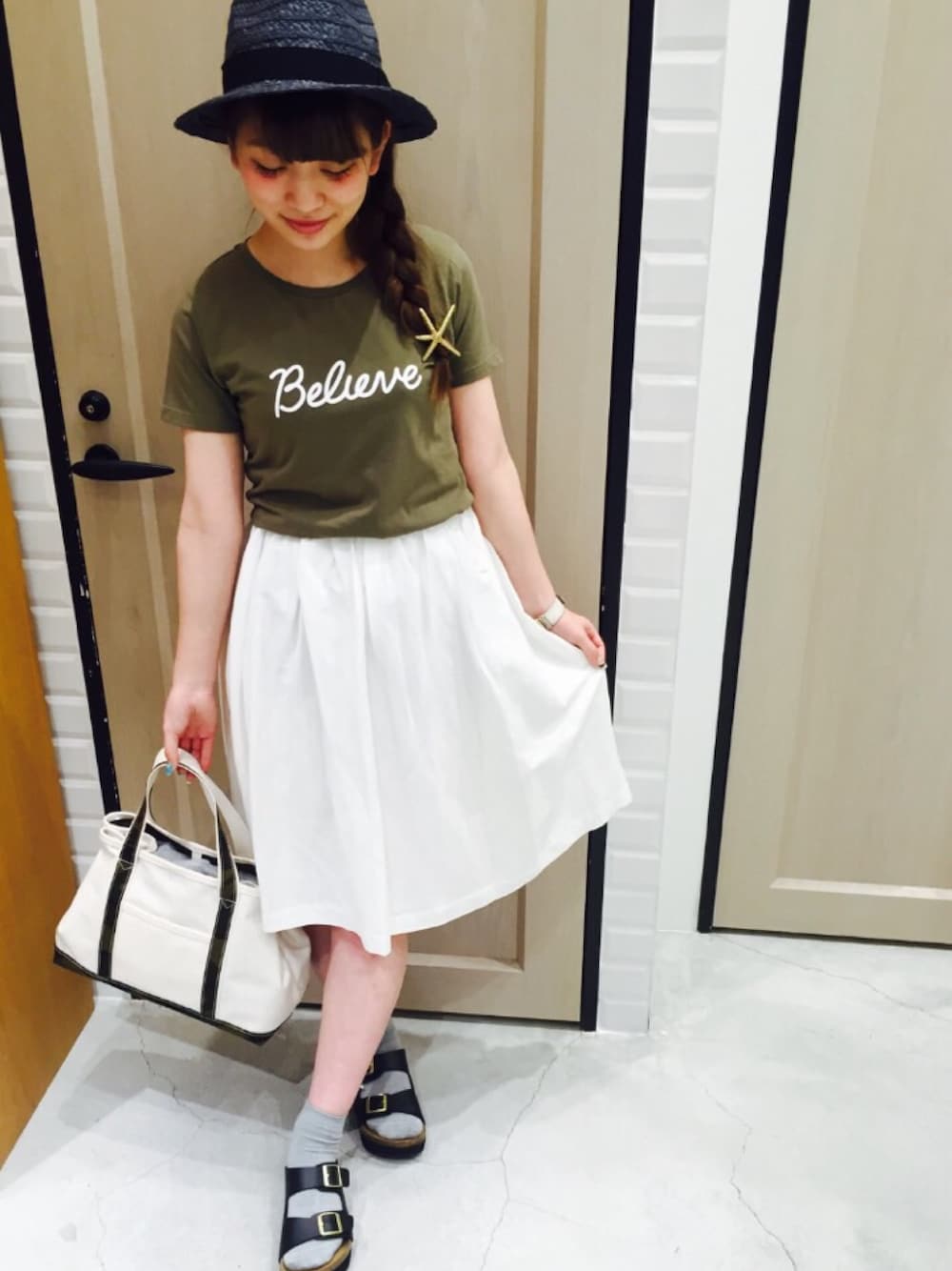 ホワイト系のスカート、グリーン系のTシャツ/カットソー、ホワイト系のトートバッグを着用したレディースの夏コーディネートの1枚目の写真