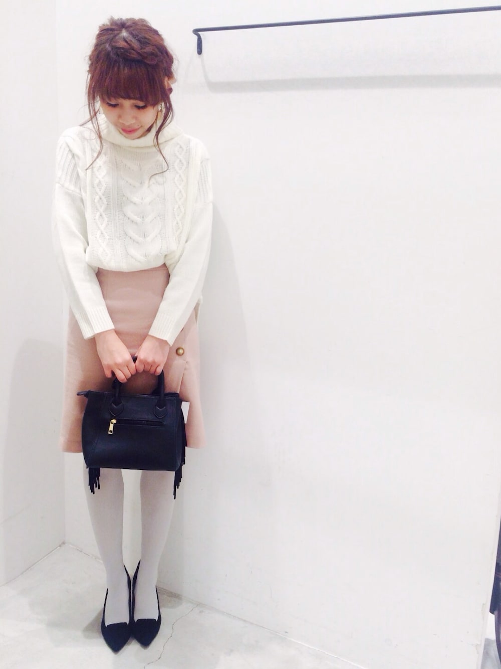 ホワイト系のニット/セーター、ピンク系のスカート、ブラック系のパンプスを着用したレディースの冬コーディネートの1枚目の写真