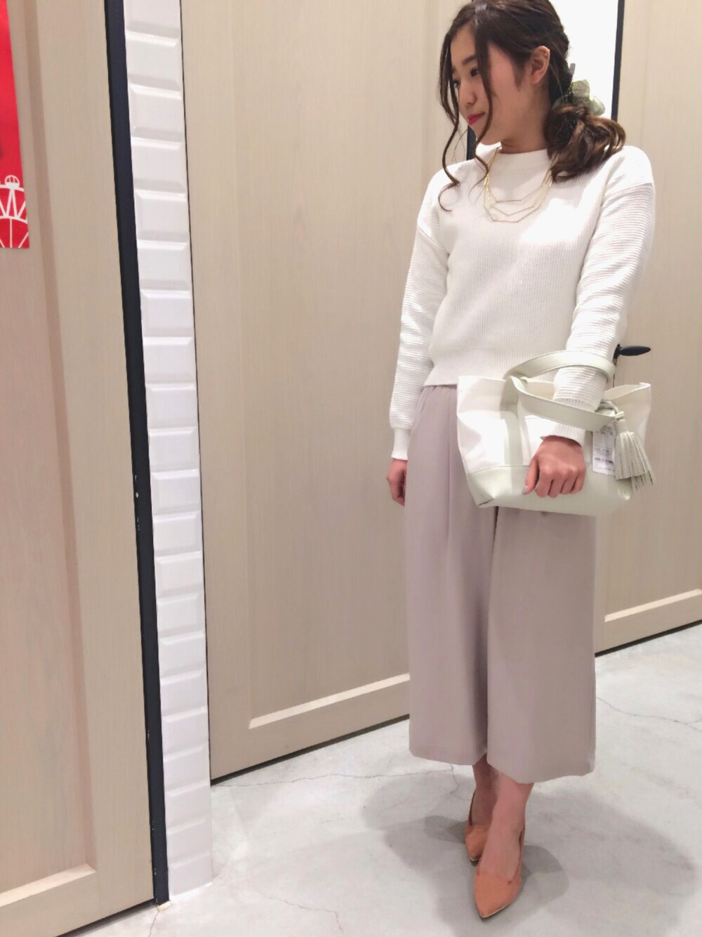 ホワイト系のニット/セーター、グレー系のパンツ、イエロー系のパンプスを着用したレディースの冬コーディネートの1枚目の写真