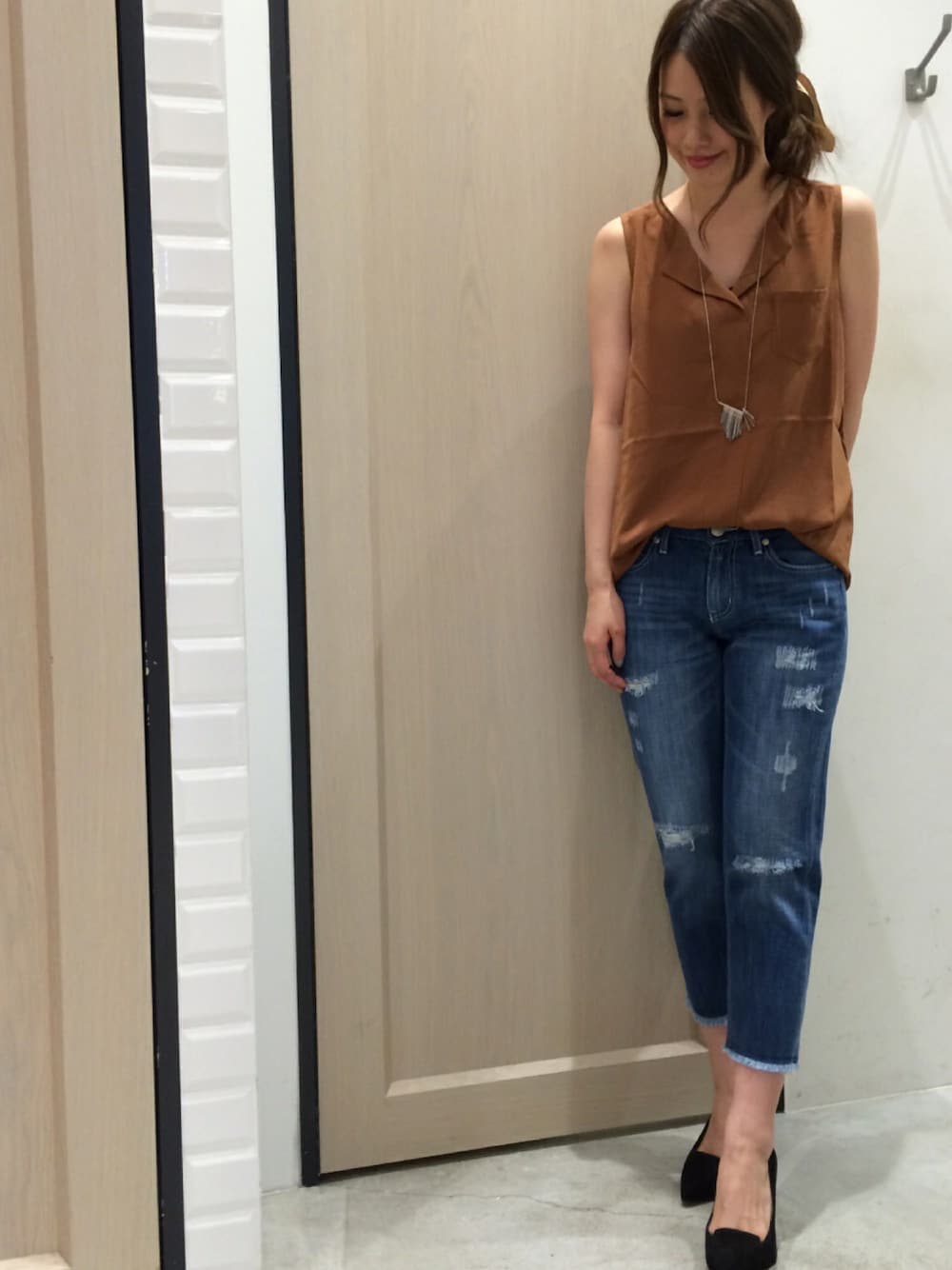 ブラウン系のトップス、ブルー系のパンツ、ブラック系のパンプスを着用したレディースの夏コーディネートの1枚目の写真