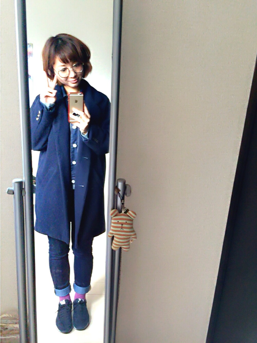 ブラック系のスニーカー、ブルー系のパンツ、ブルー系のチェスターコートを着用したレディースの冬コーディネートの1枚目の写真