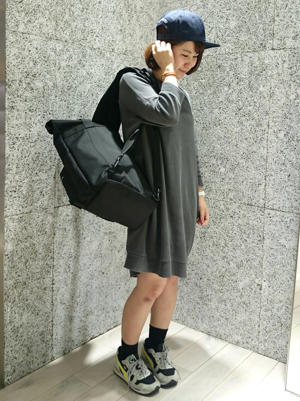 ブラック系のバックパック/リュック、ブルー系のキャップを着用したレディースの夏コーディネートの1枚目の写真